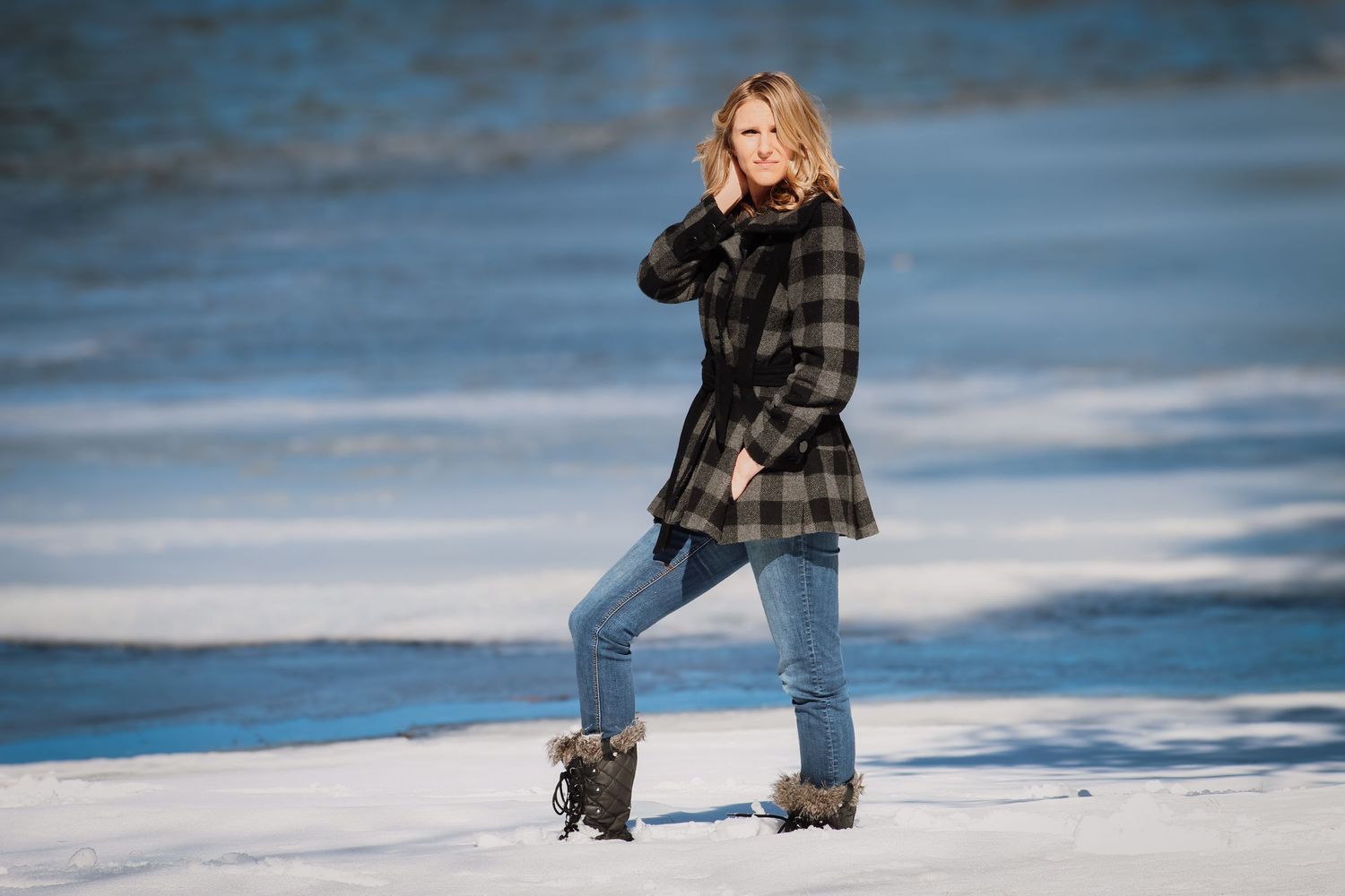 A person in winter attire stands in a snowy landscape against a blue-tinted background.