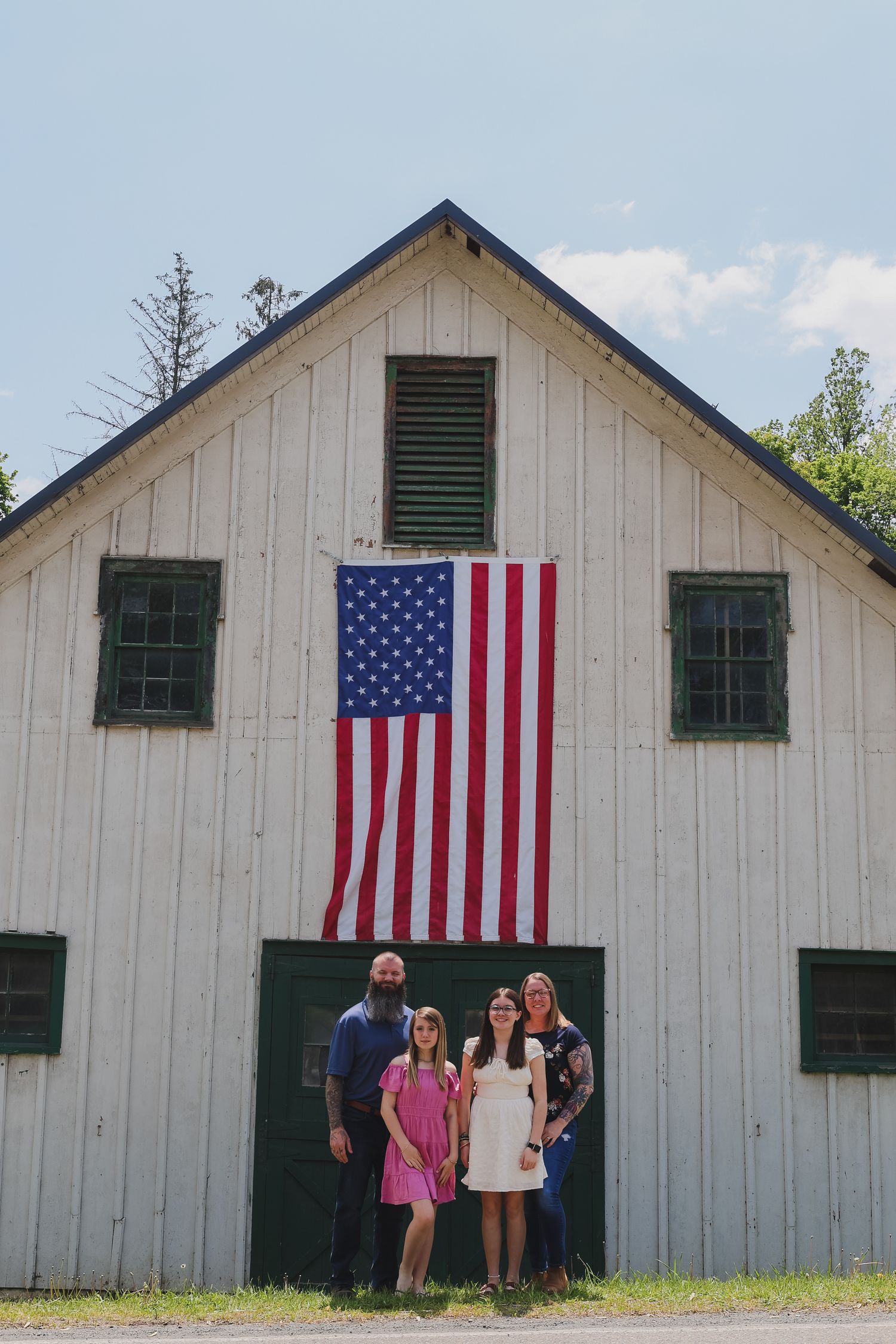 A sequence of photos showing a white barn with green shutters and American flags displayed on its exterior.