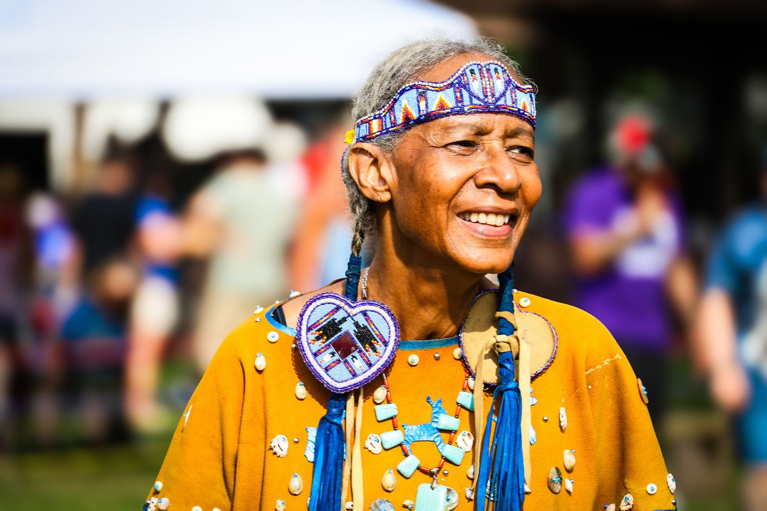 A performer in traditional Native American regalia with colorful beadwork dances at a cultural celebration.