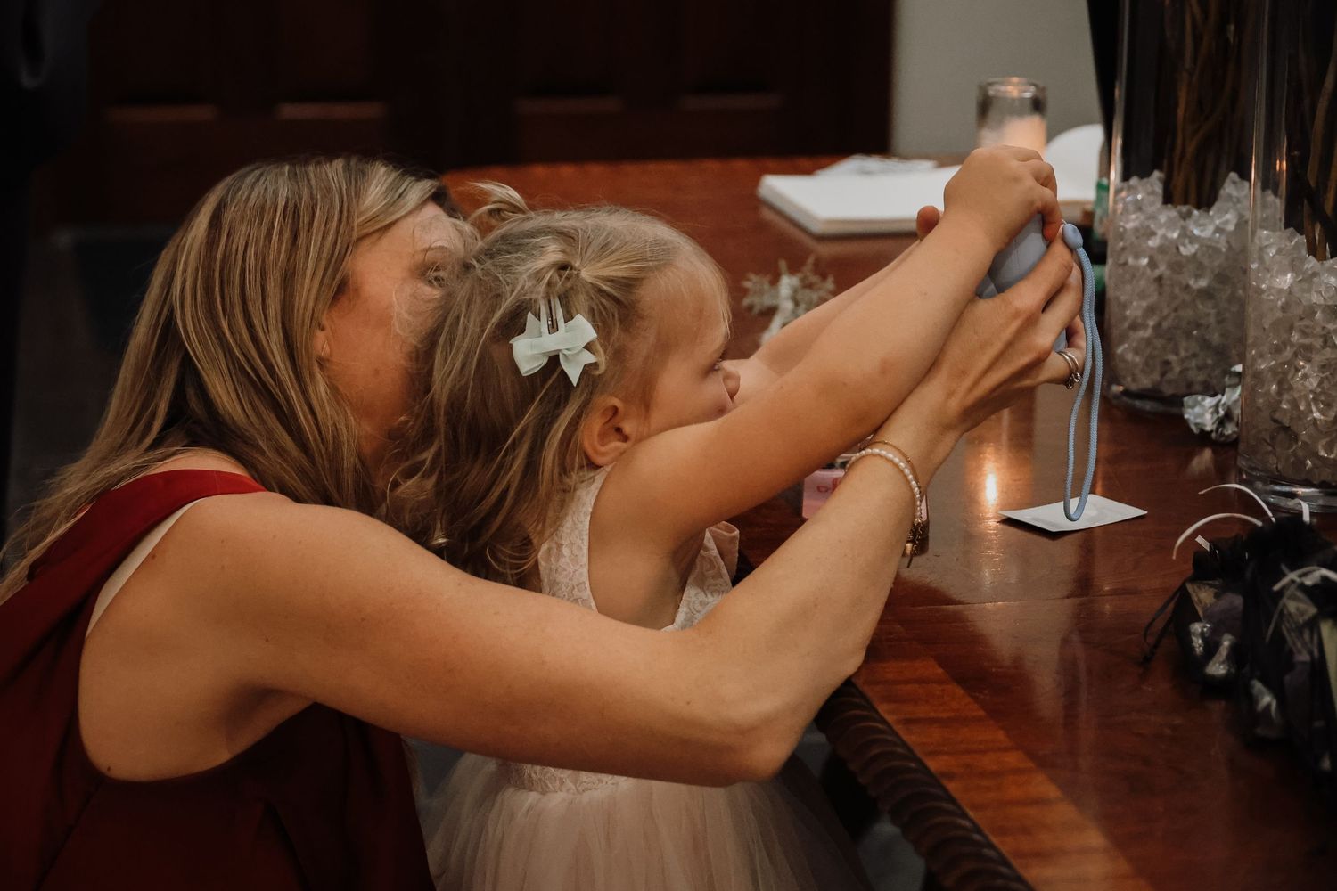 Two people sharing a passionate kiss at a wedding reception or formal event.