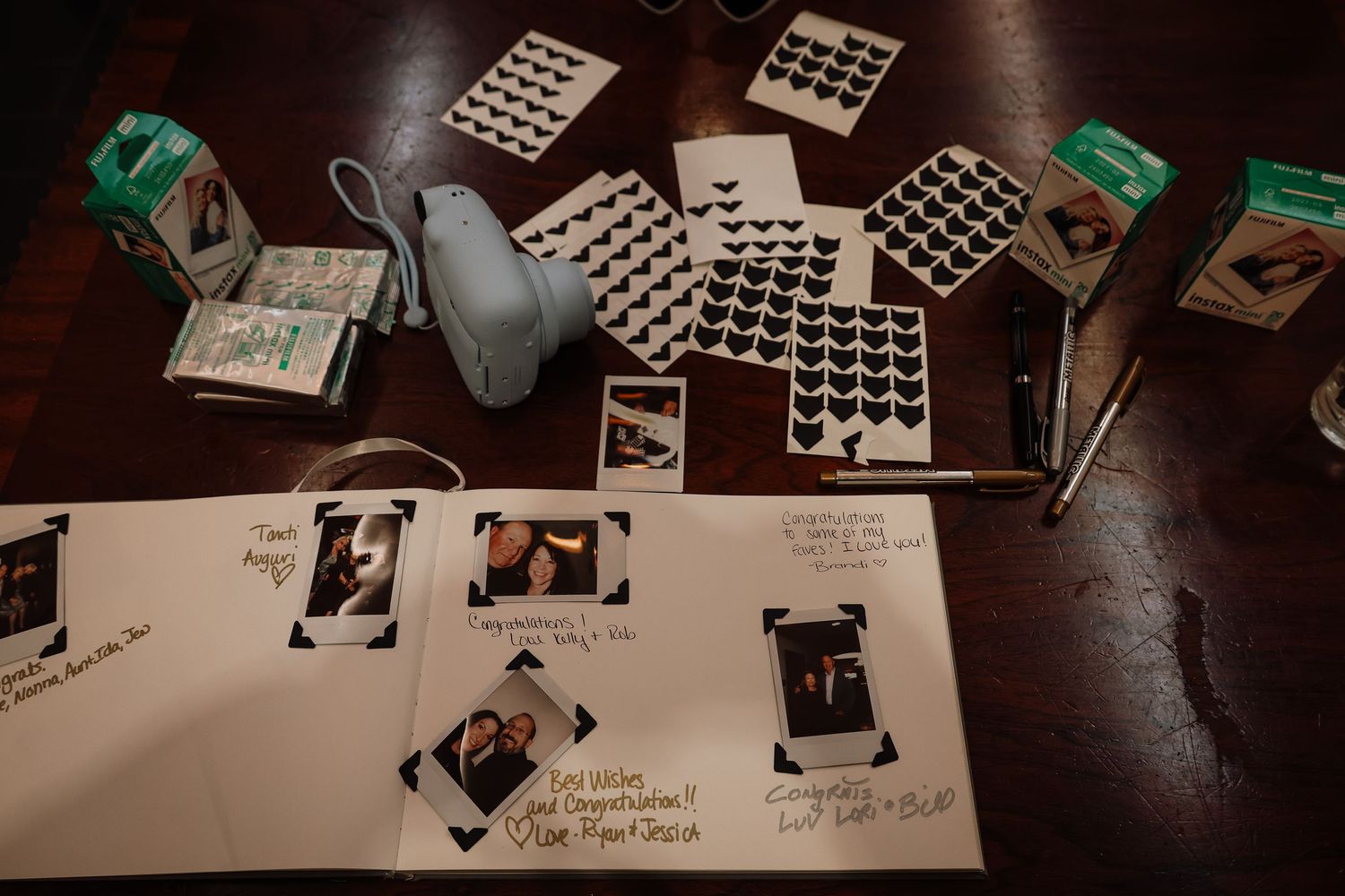 Photo strips and negatives spread out on a dark wooden surface showing various film photography prints.