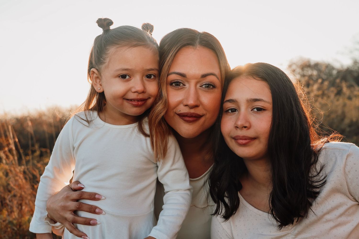 A collection of outdoor family portrait photos at sunset showing warm embraces and smiles.