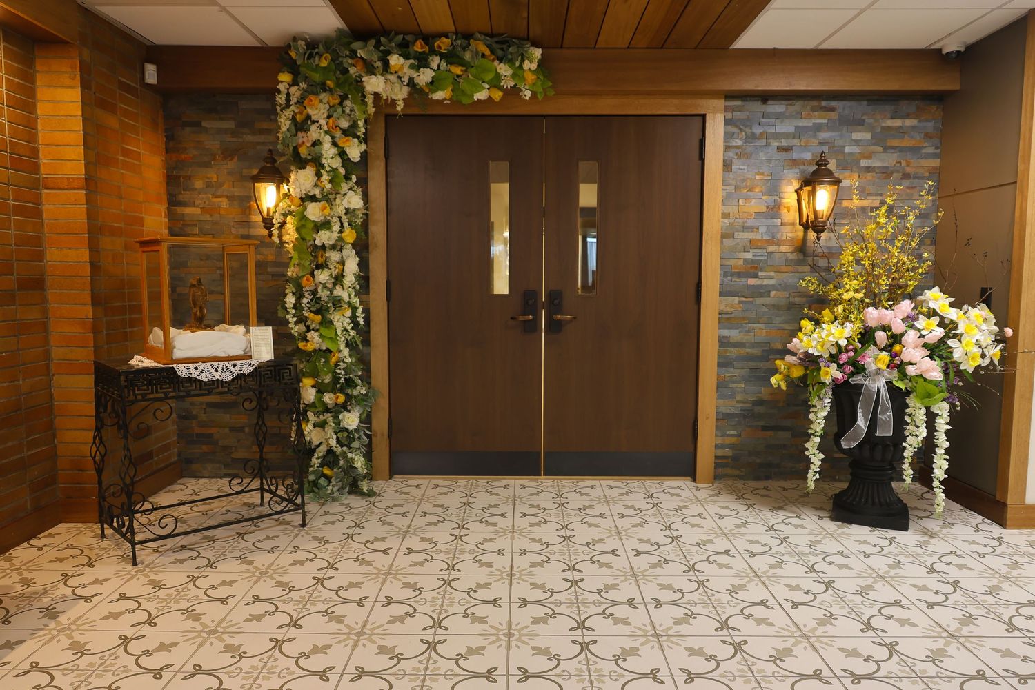 Modern banquet hall interior with wood paneling, stone accents and decorative lighting fixtures.