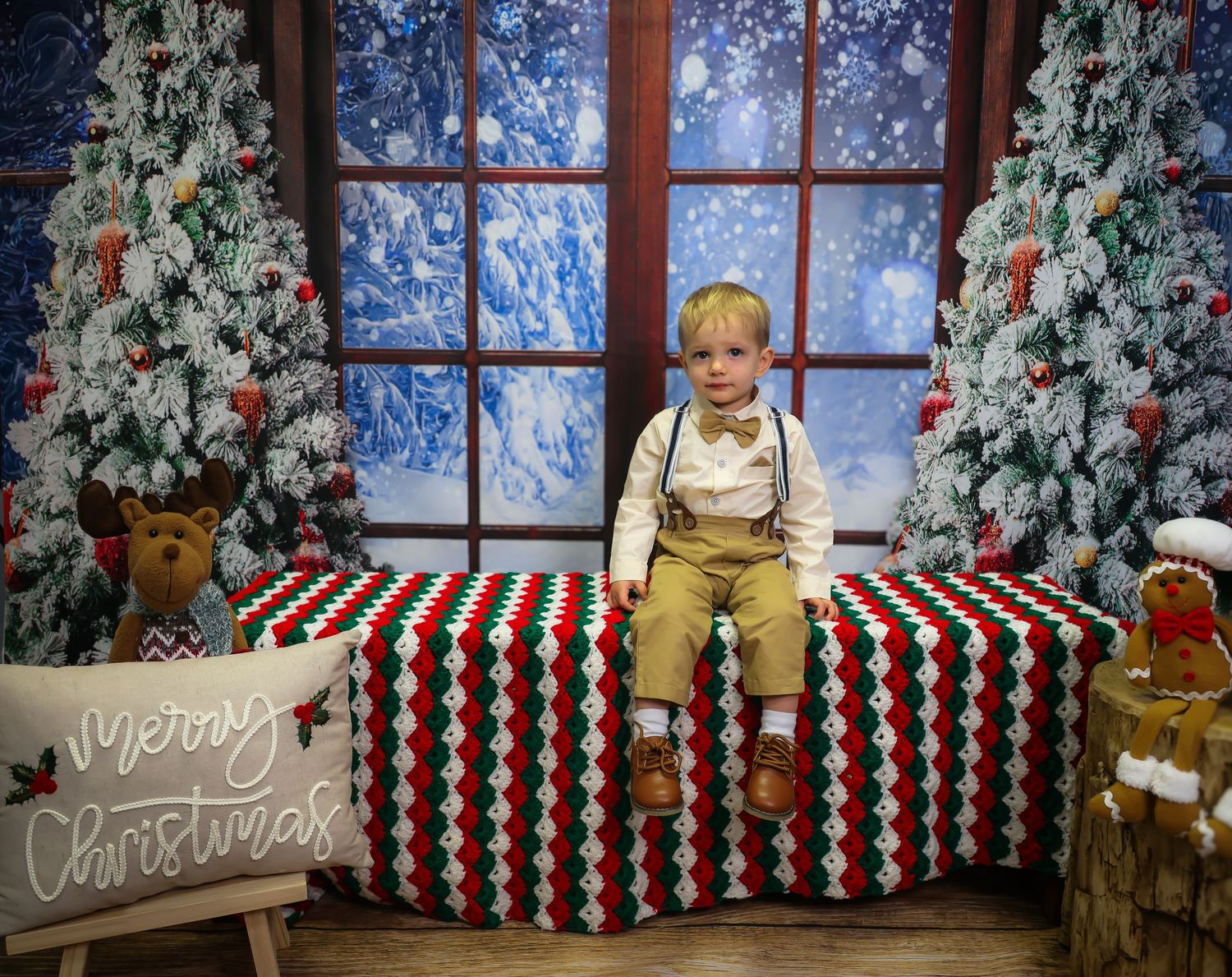Holiday photo backdrop with decorated Christmas trees, striped benches, and festive winter decor against a snowy scene.