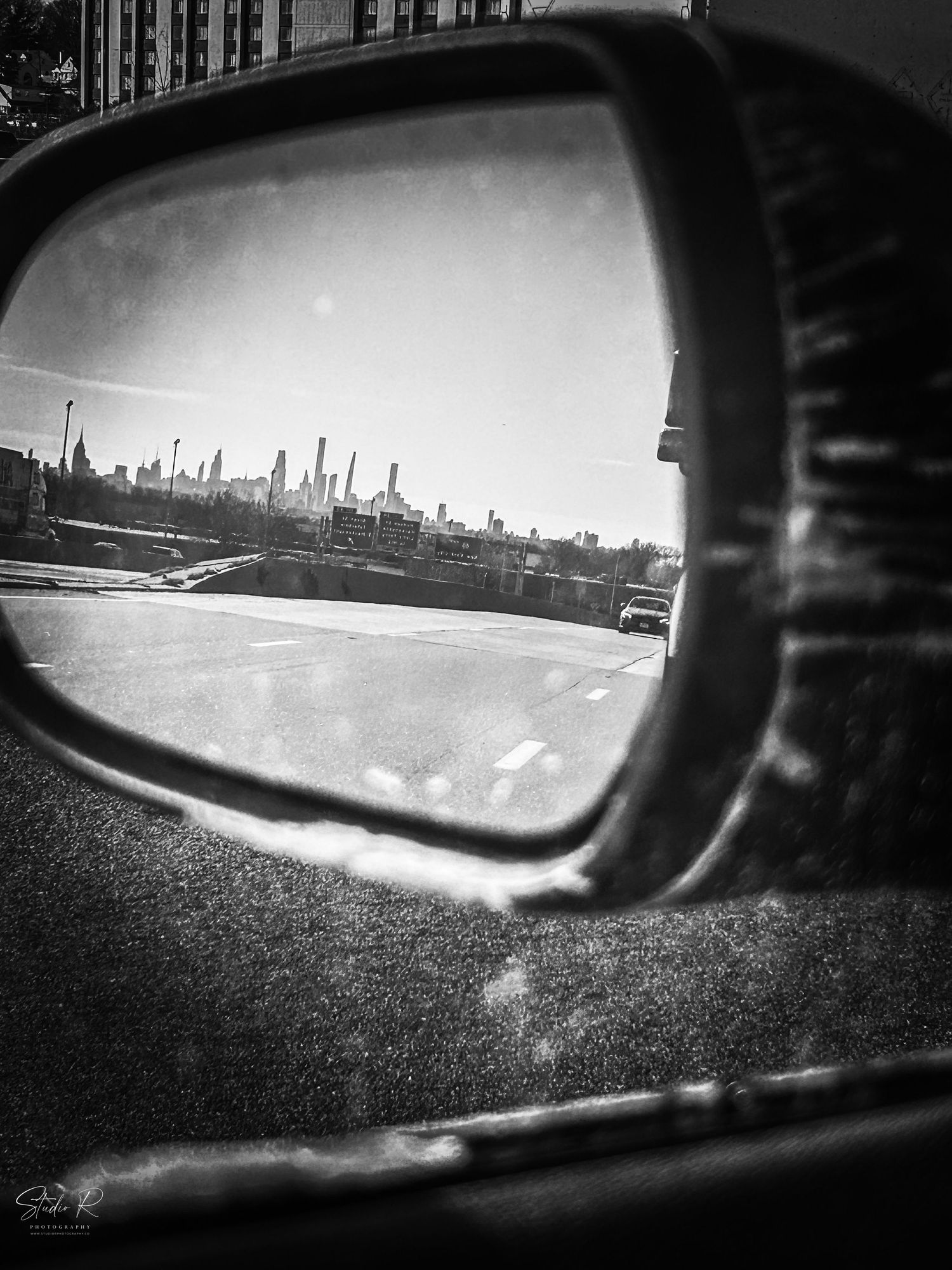 Black and white cityscape reflections seen through car side mirrors create a moody urban perspective series.
