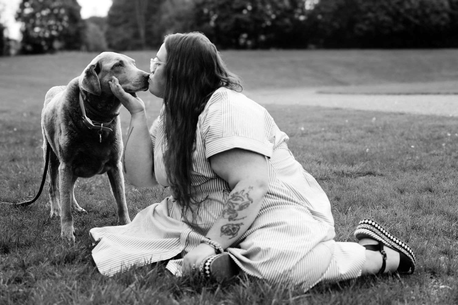 A black and white photo series showing tender moments between a couple lying in the grass.
