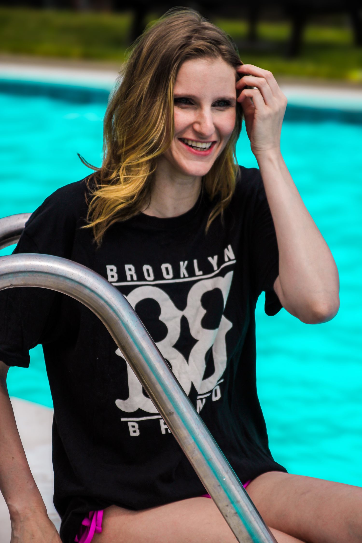 A series of photos showing someone wearing a black t-shirt with a white logo by a bright blue swimming pool.