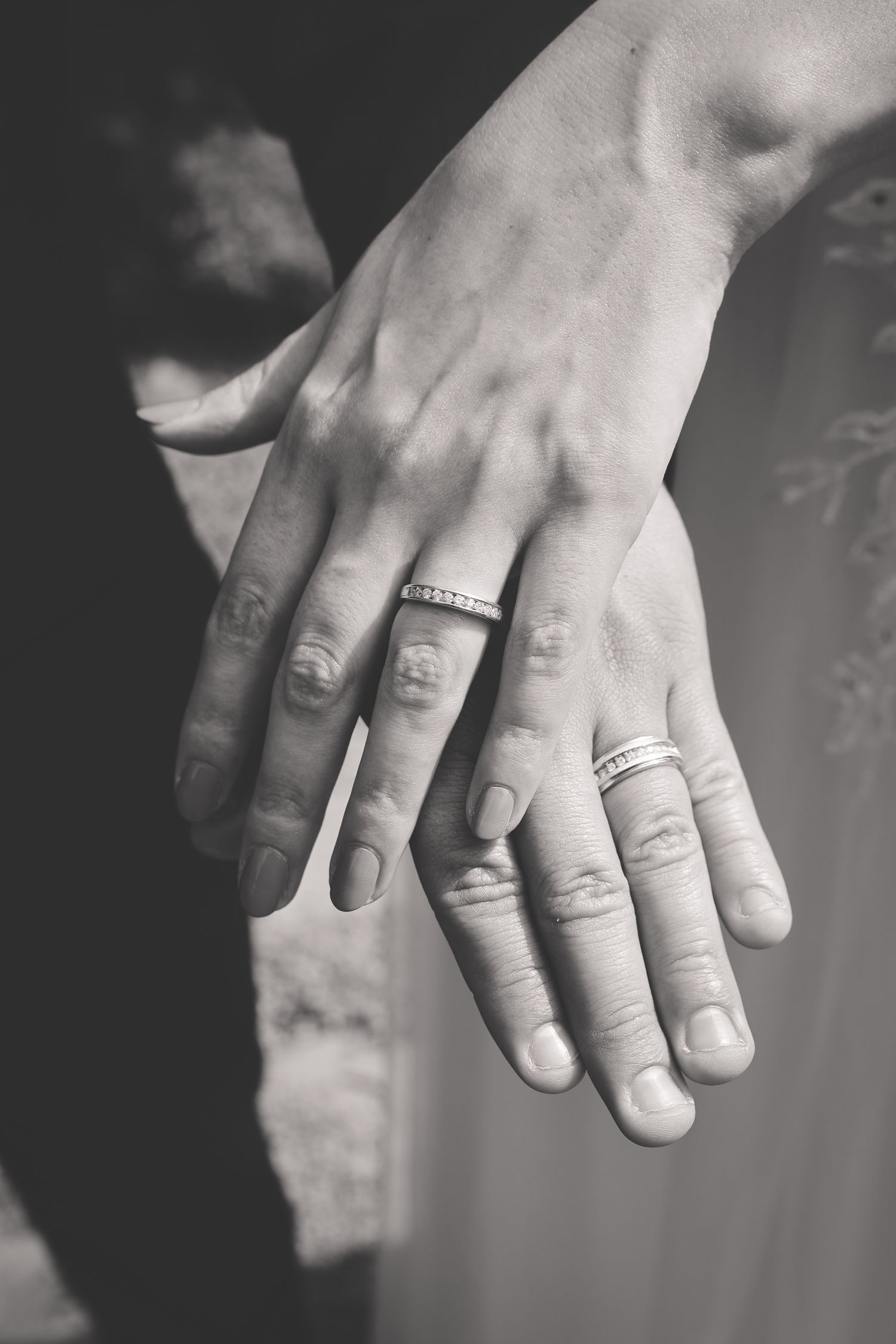 Black and white close-up photos of hands showing matching tattoos and rings in a series of artistic shots.