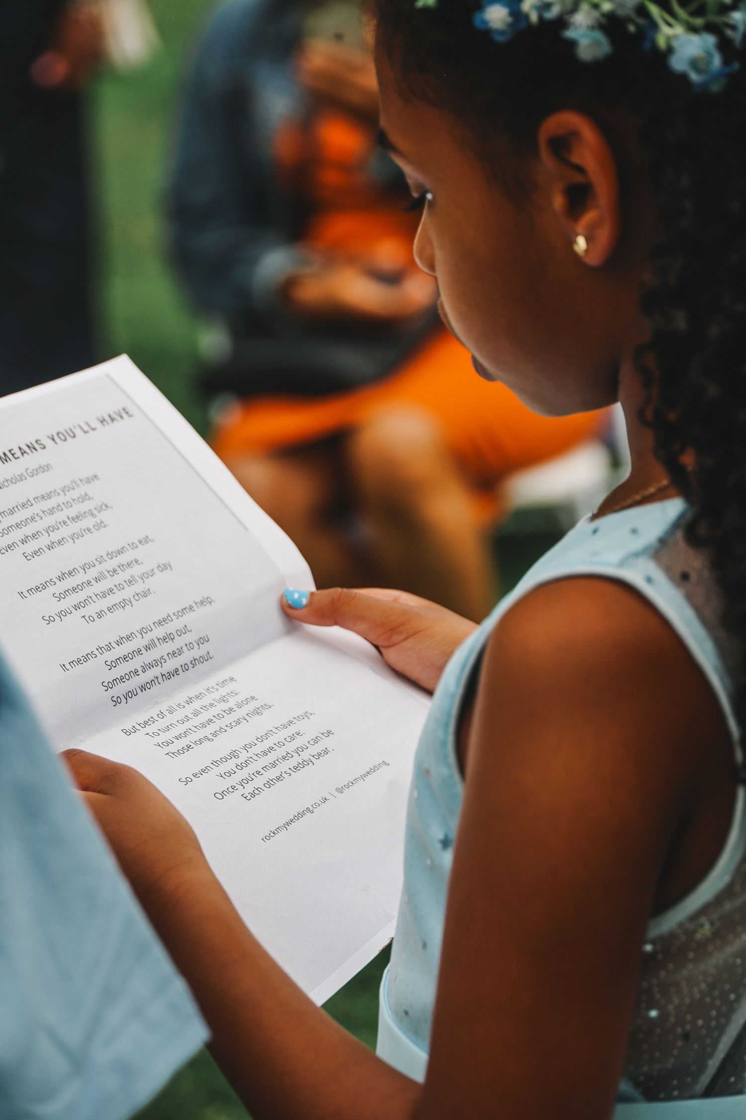 A student reads from a printed paper handout during a class or educational activity.