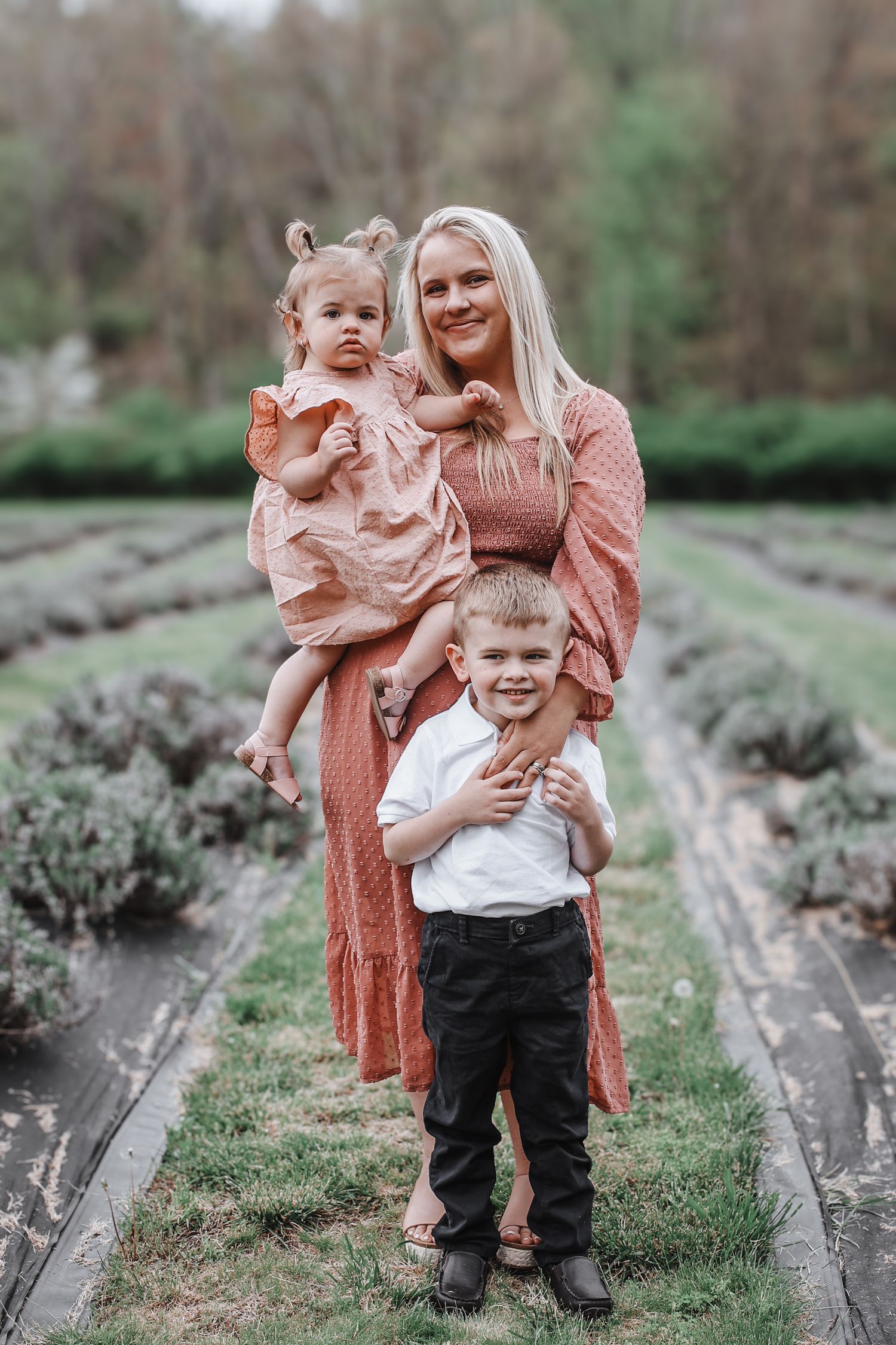 A family shares playful moments together outdoors in a garden setting with natural greenery in the background.