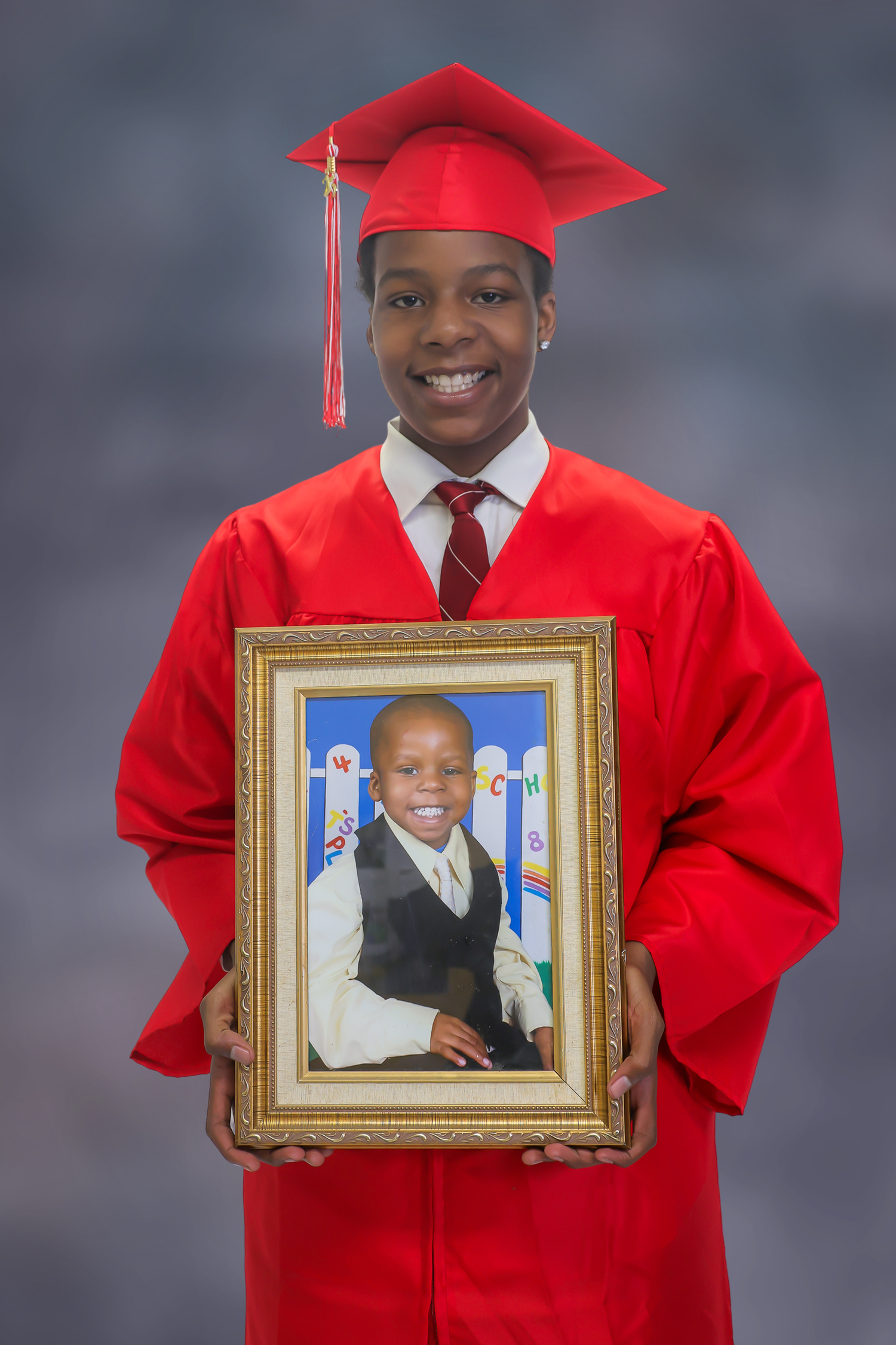 Graduate in red cap and gown holds up framed childhood portrait in progression series of four photos.