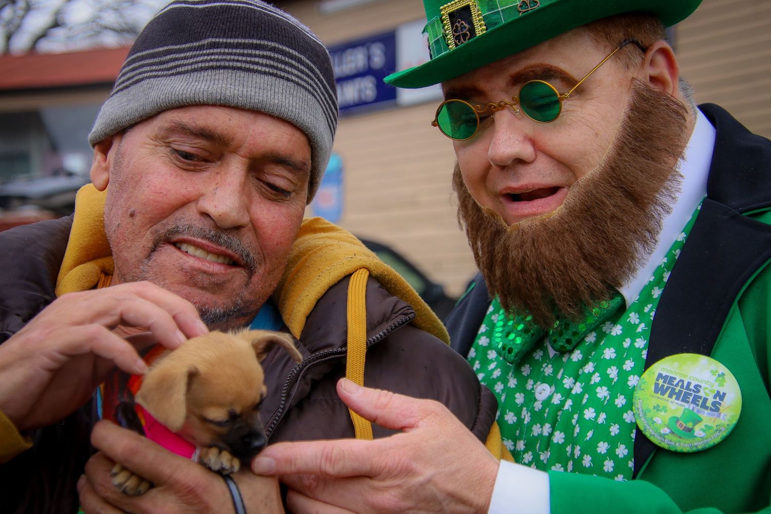Group wearing green St. Patrick's Day accessories and festive attire gathered together outside.