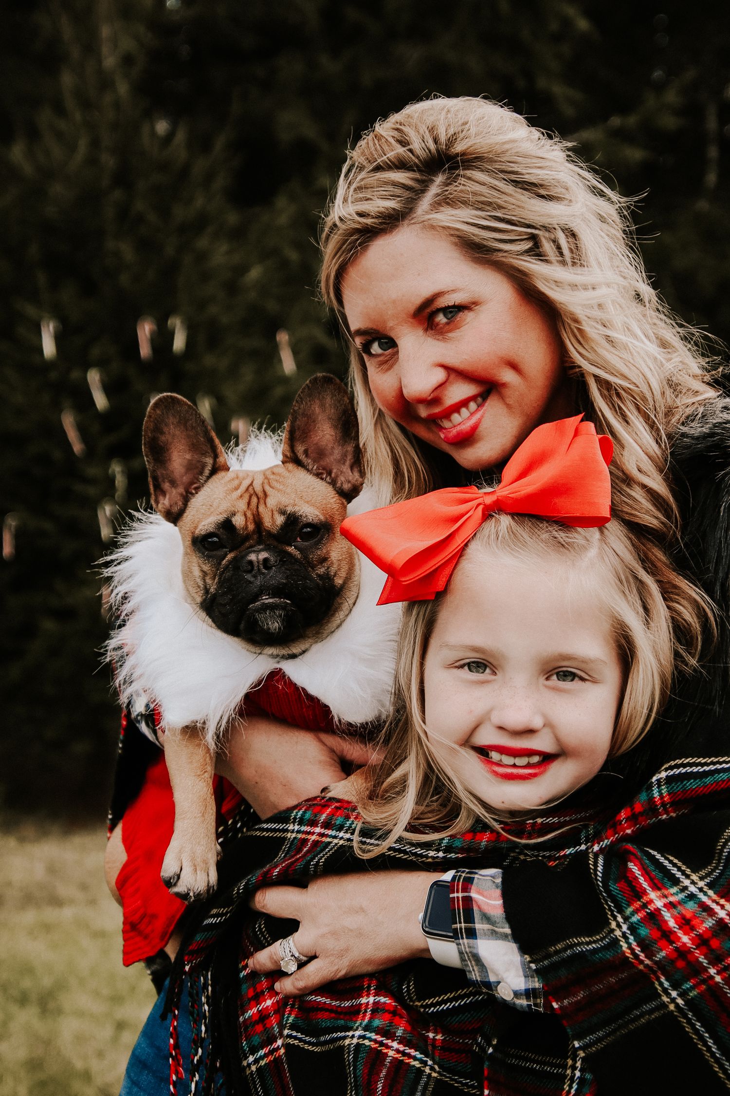 A series of candid photos showing a child in plaid hugging a black and white dog with a red bow.