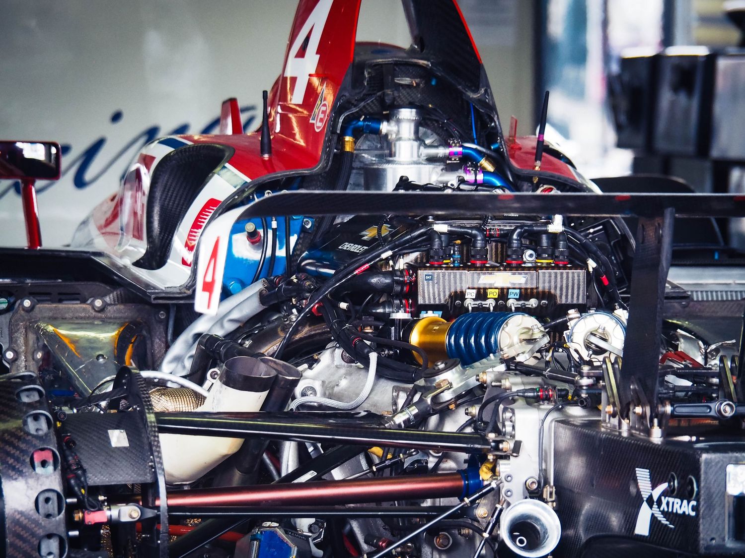 Close-up view of a Formula 1 car's exposed internal components showing suspension, wiring and mechanical parts.