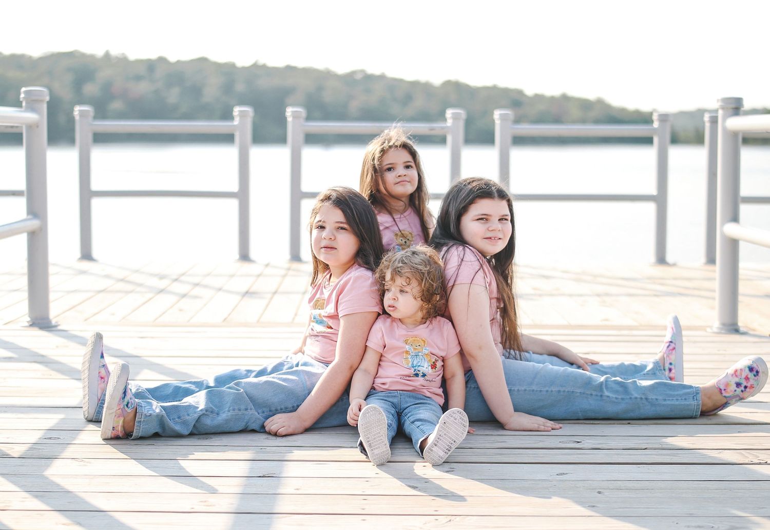 Group relaxing together on wooden dock by the water on sunny summer day.