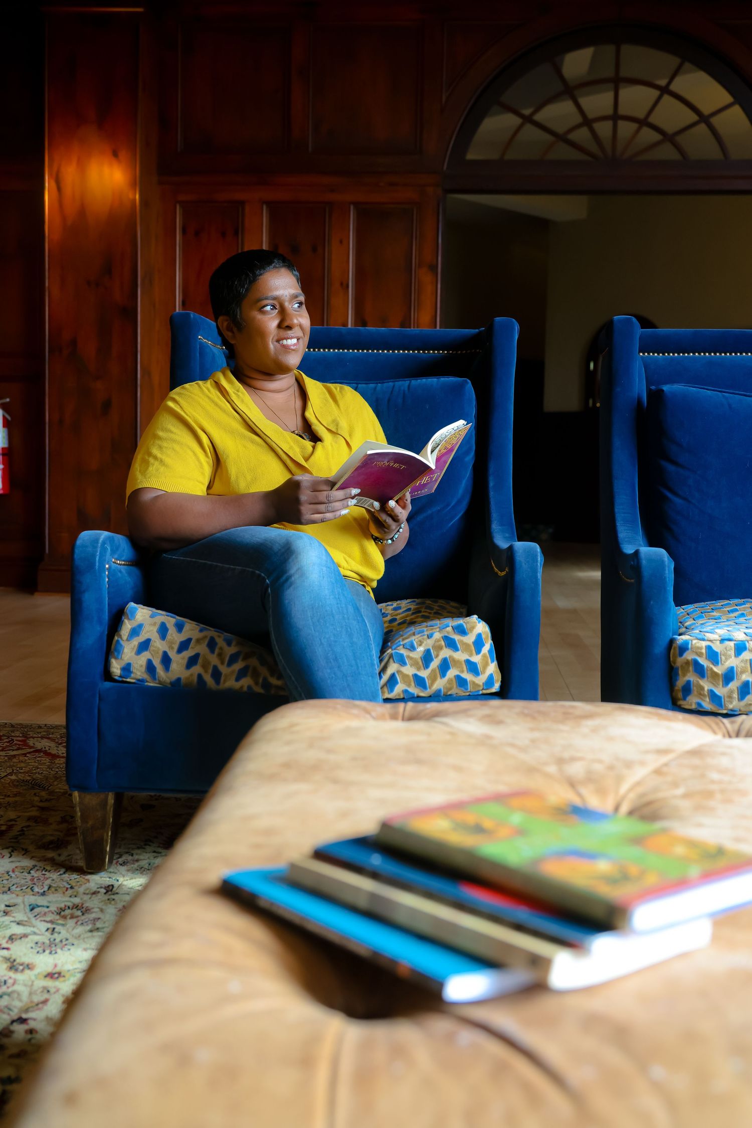 A series of photos showing someone in a yellow shirt reading a book while sitting on a bright blue couch.