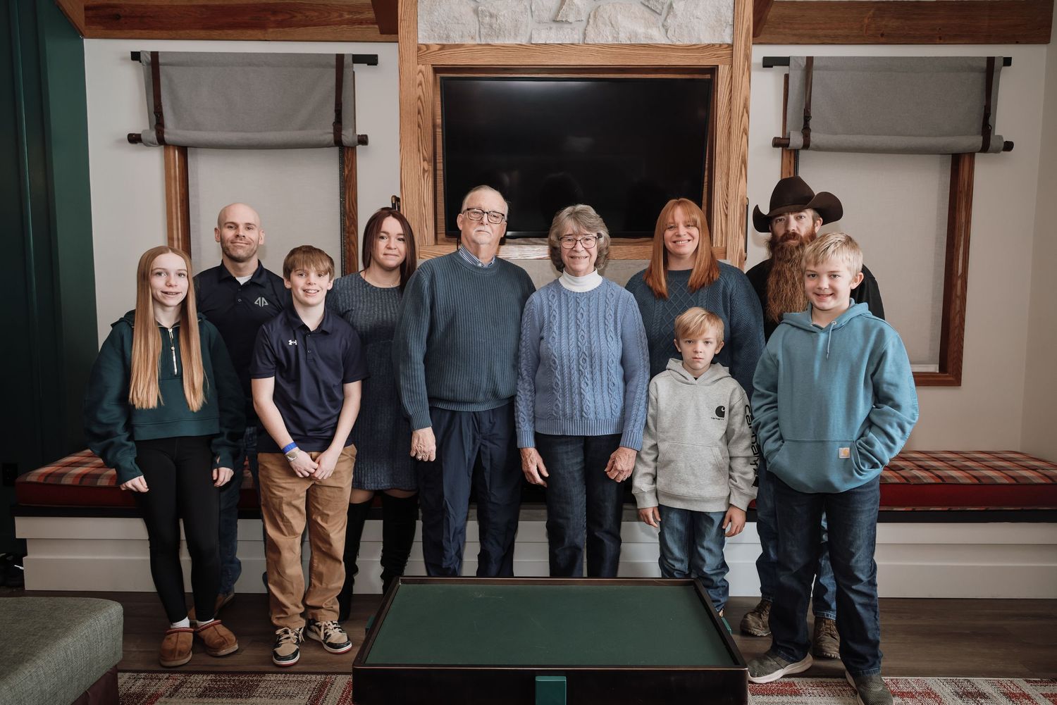 Group of people standing together in a rustic indoor setting with wooden walls and decor.