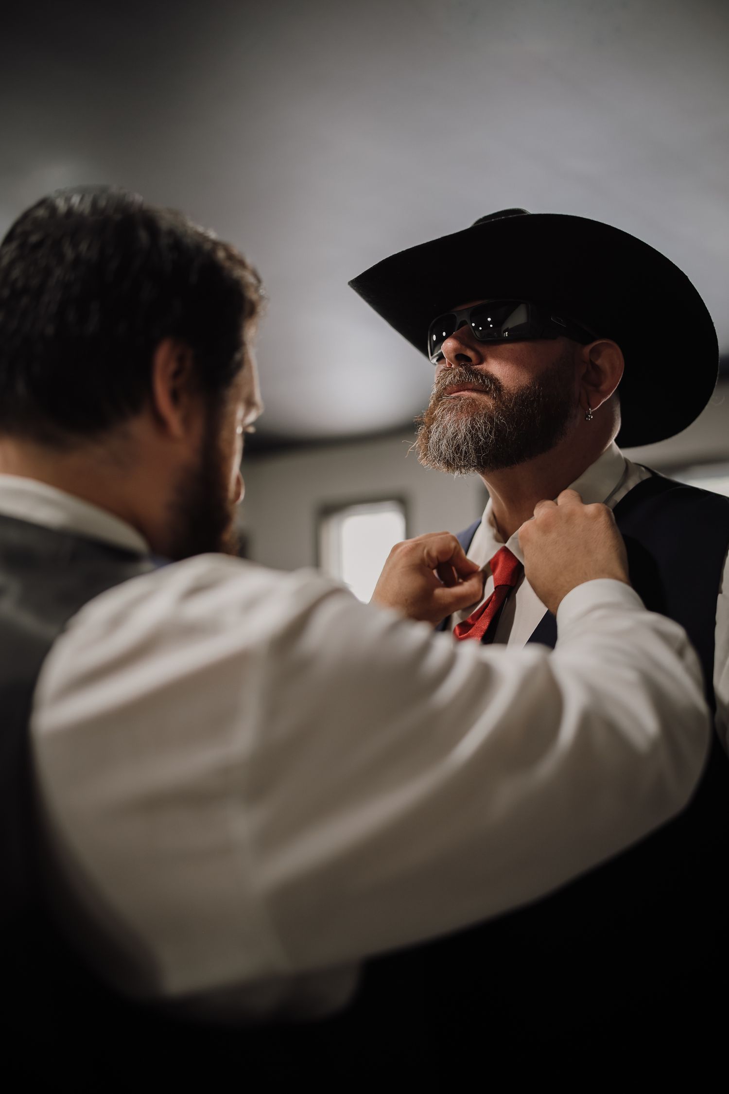 A series of dark silhouettes show someone in white sleeves and a cowboy hat in a moody, cinematic composition.