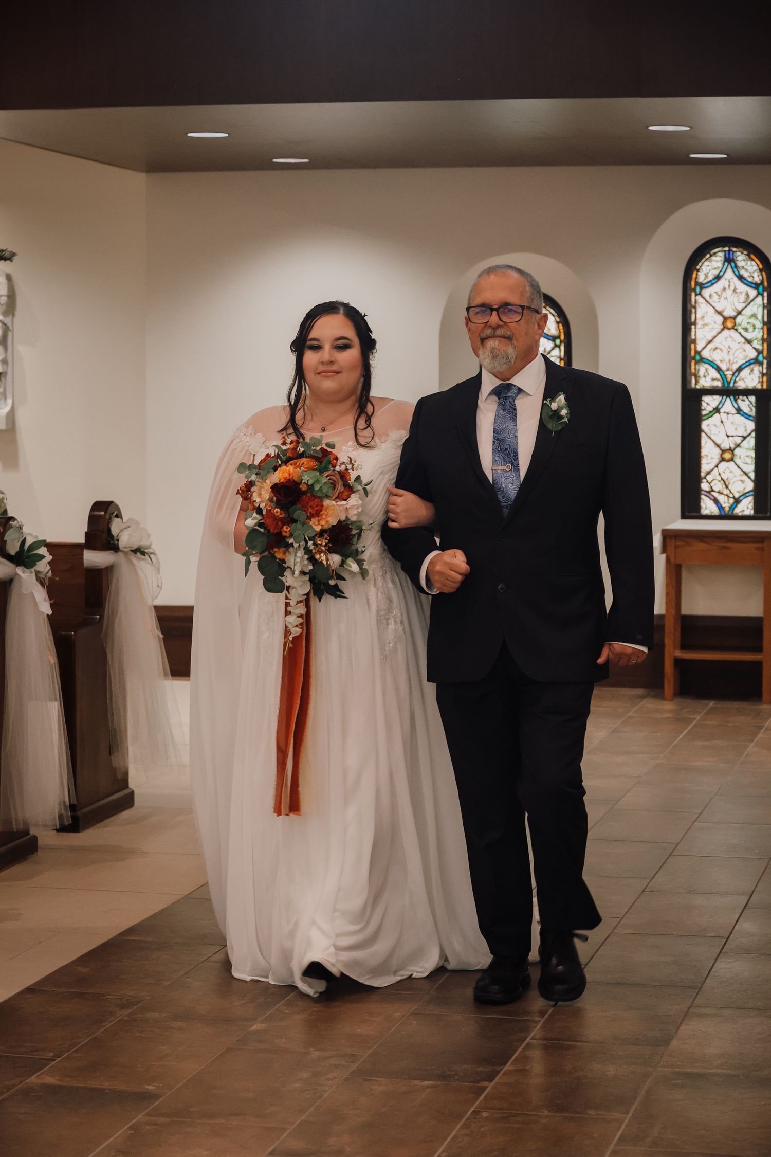 A wedding processional sequence showing a bride and escort walking down a church aisle with stained glass windows.