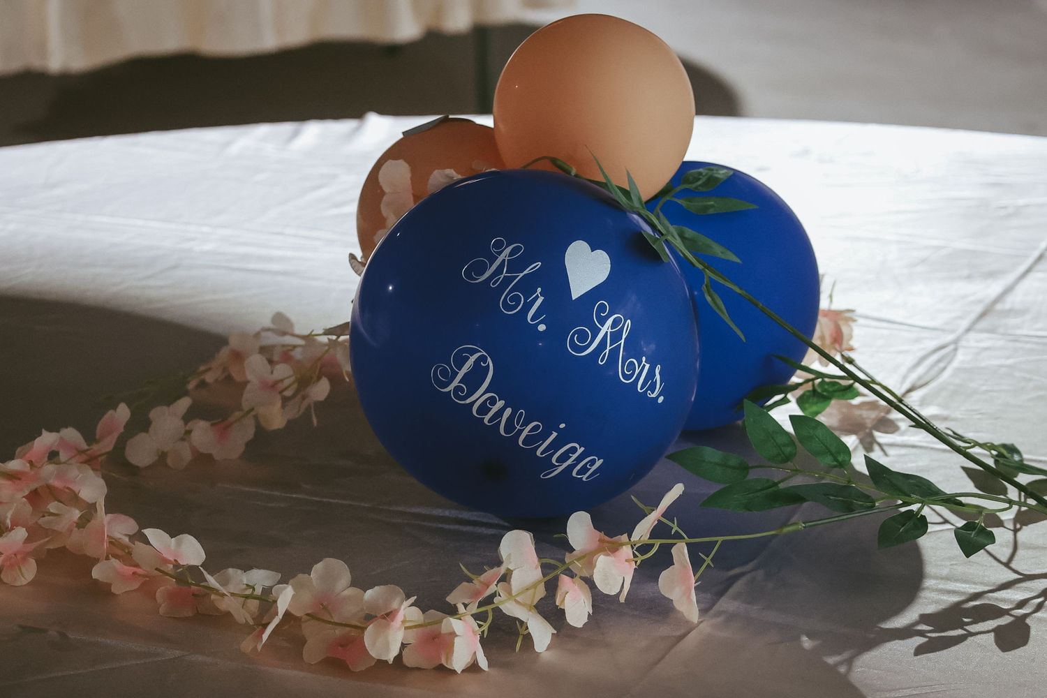 Blue wedding guest book with pearl accents and floral decorations displayed on a light surface.