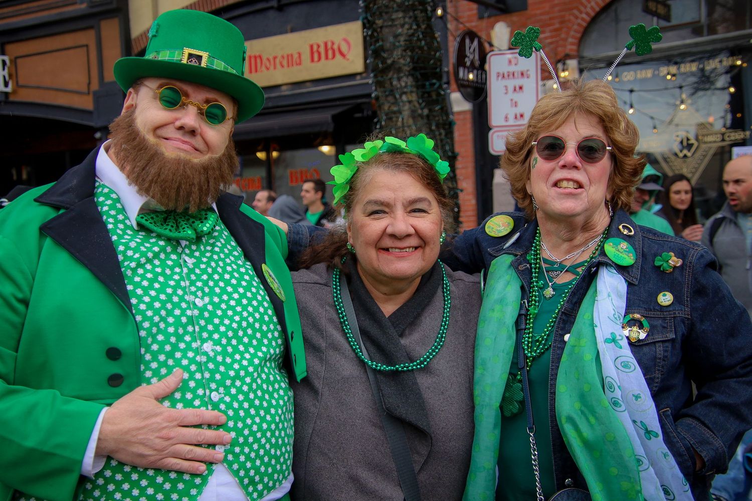People celebrating St Patrick's Day wearing green clothing and shamrock accessories at a festive gathering.