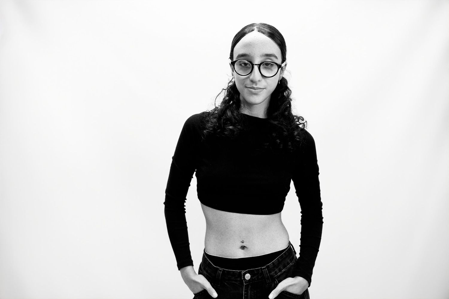 Woman in black crop top and glasses poses in four different casual stances against white background.