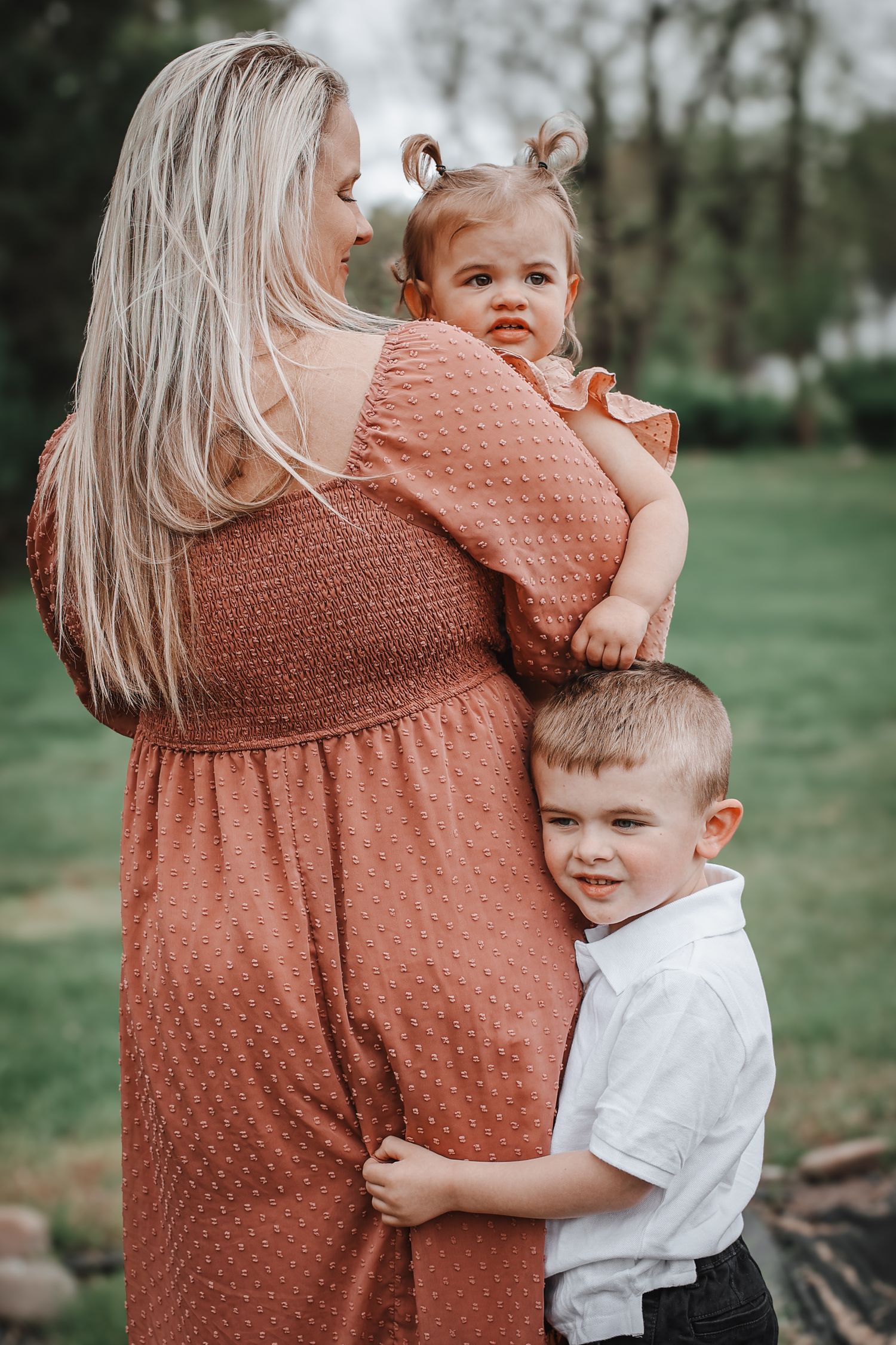 A series of tender outdoor family moments captured in soft natural lighting showing affectionate embraces and smiles.