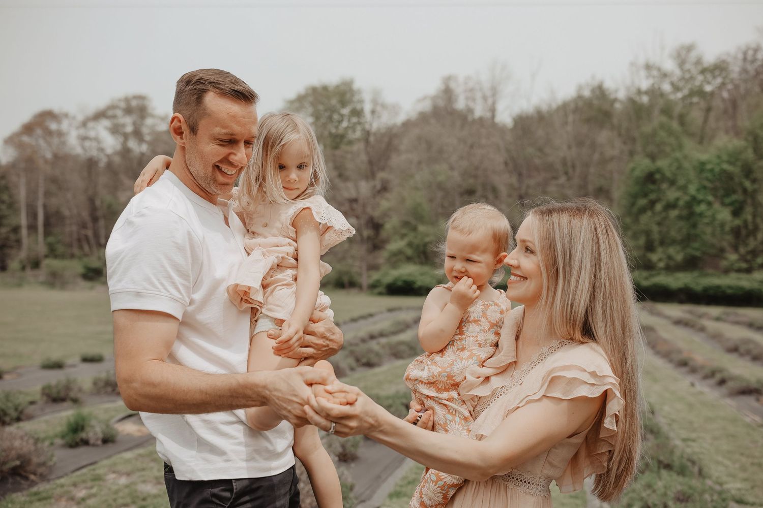 Family enjoying a tender moment together outdoors in a natural setting during golden hour.