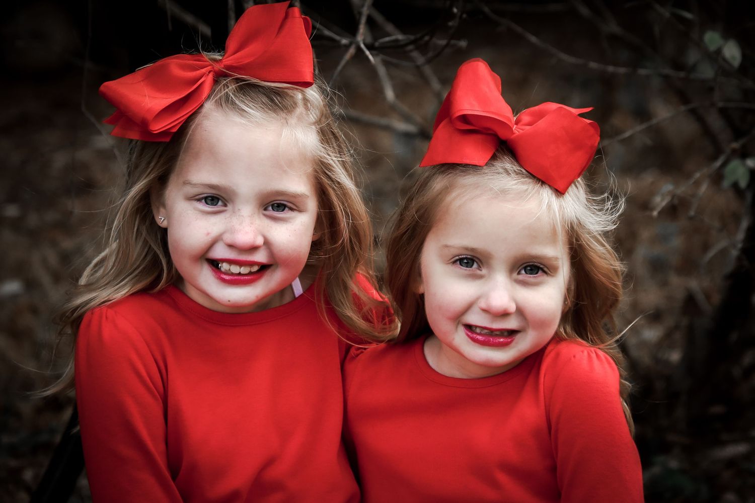 A series of candid photos showing two young children in matching red outfits and bows against a dark background.