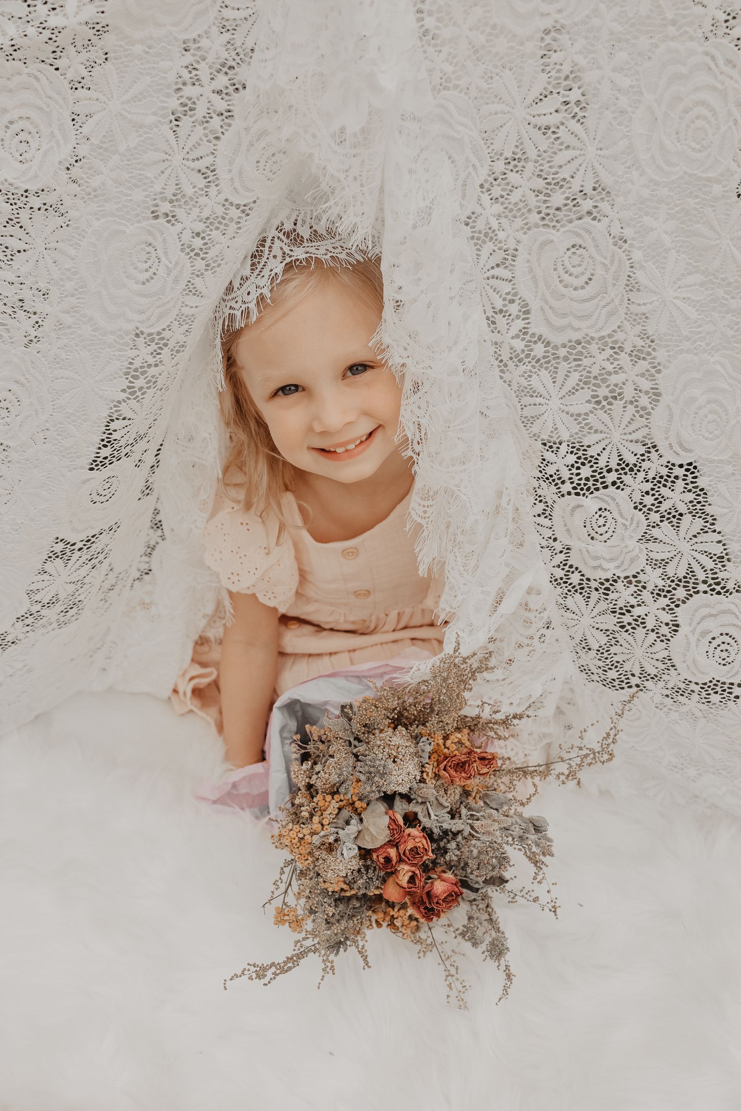 Ethereal series of photos showing someone holding dried floral arrangements against a delicate lace background.