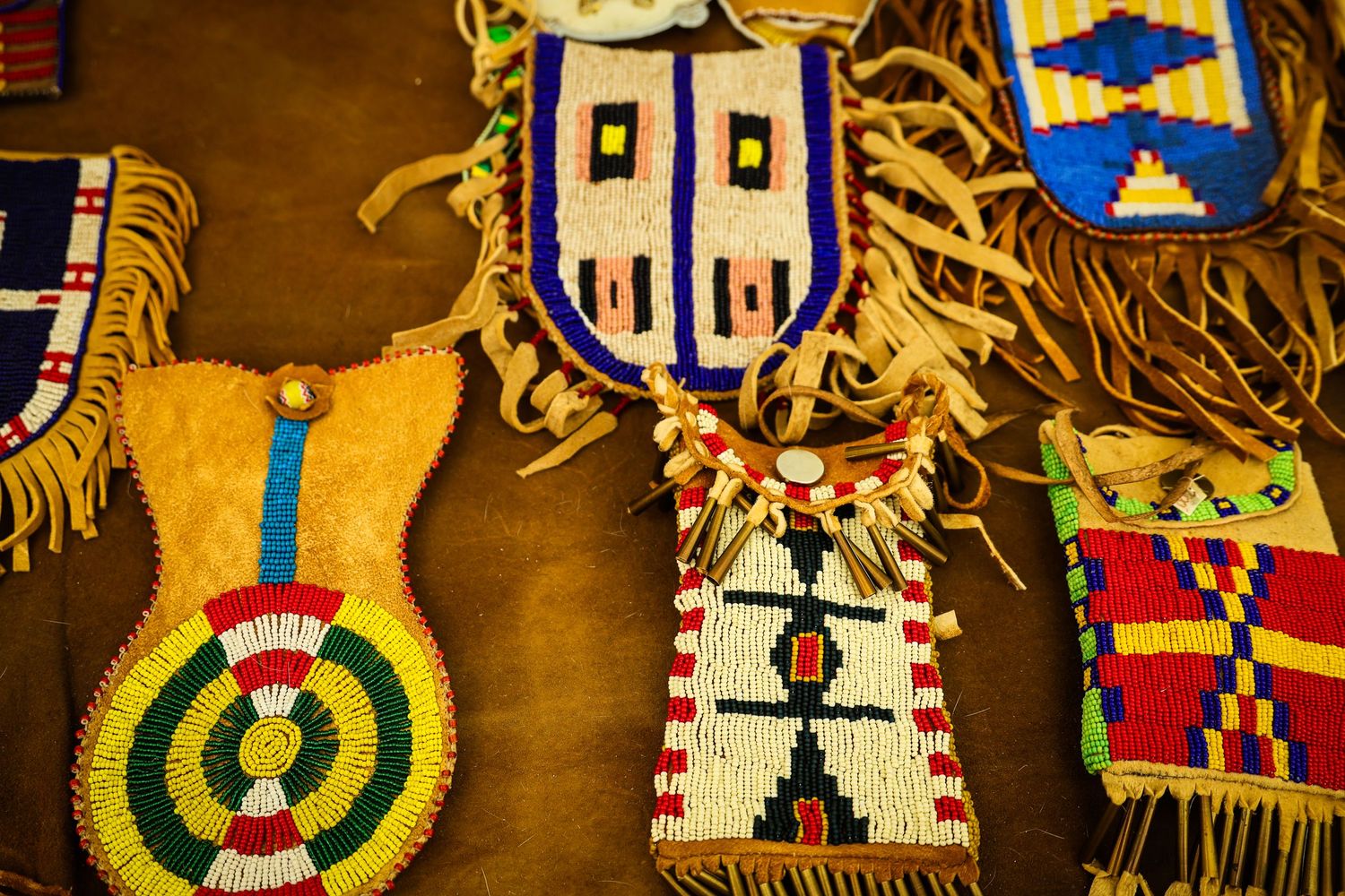 Colorful traditional Kachina dolls with intricate designs and patterns displayed in a row.