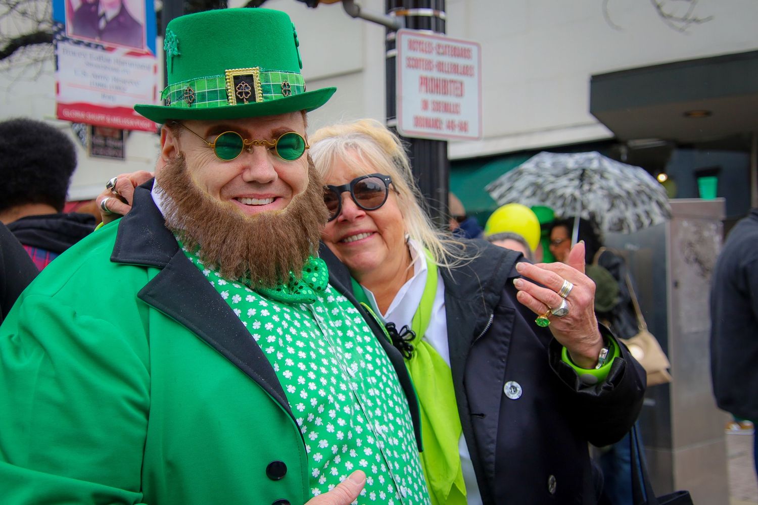 People celebrating St Patrick's Day wearing bright green outfits, hats and shamrock patterns at a festive gathering.