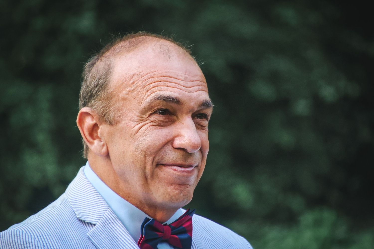 A collage of four close-up photos showing someone in a striped shirt and tie with varying expressions.