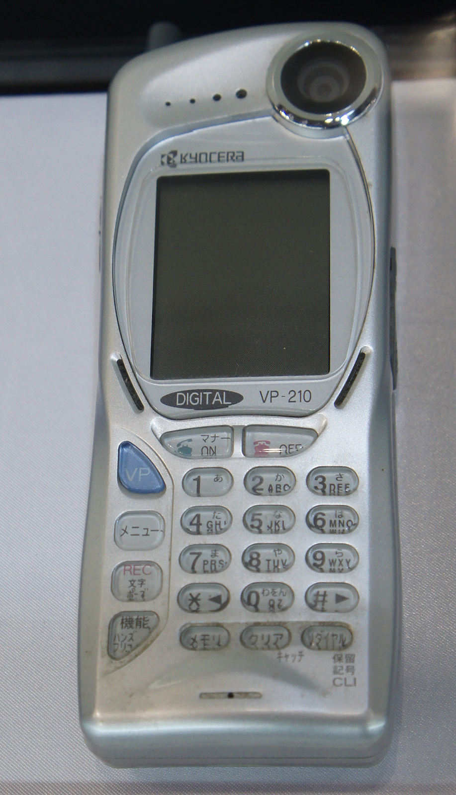 Five side-by-side views of a vintage Kyocera VP-210 mobile phone with a small digital display and keypad from different angles.