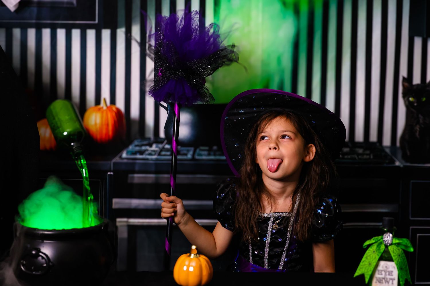 People enjoying Halloween-themed party with glowing green lights, pumpkin decorations and festive drinks.