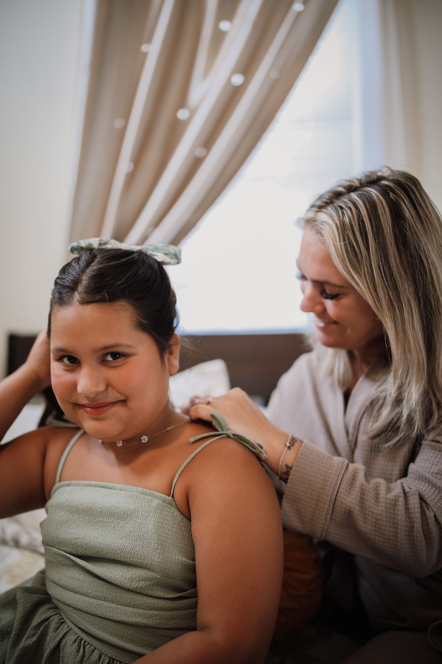 A series of four connected images showing a person getting their hair styled in a warm, softly lit room.
