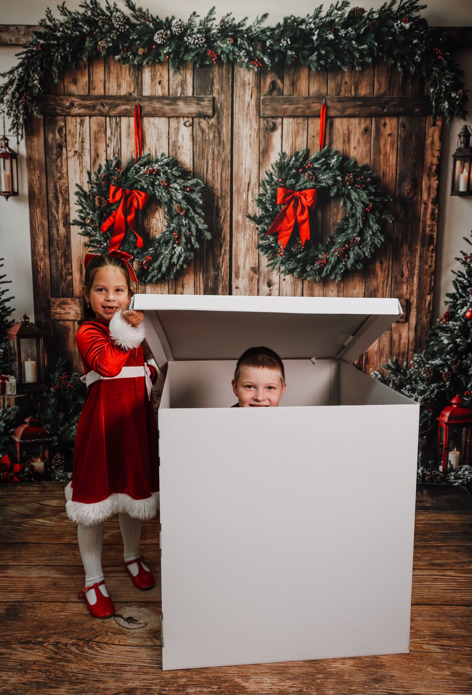 Four sequential photos show a Christmas scene with a white gift box prop and evergreen garland against a rustic wooden wall.