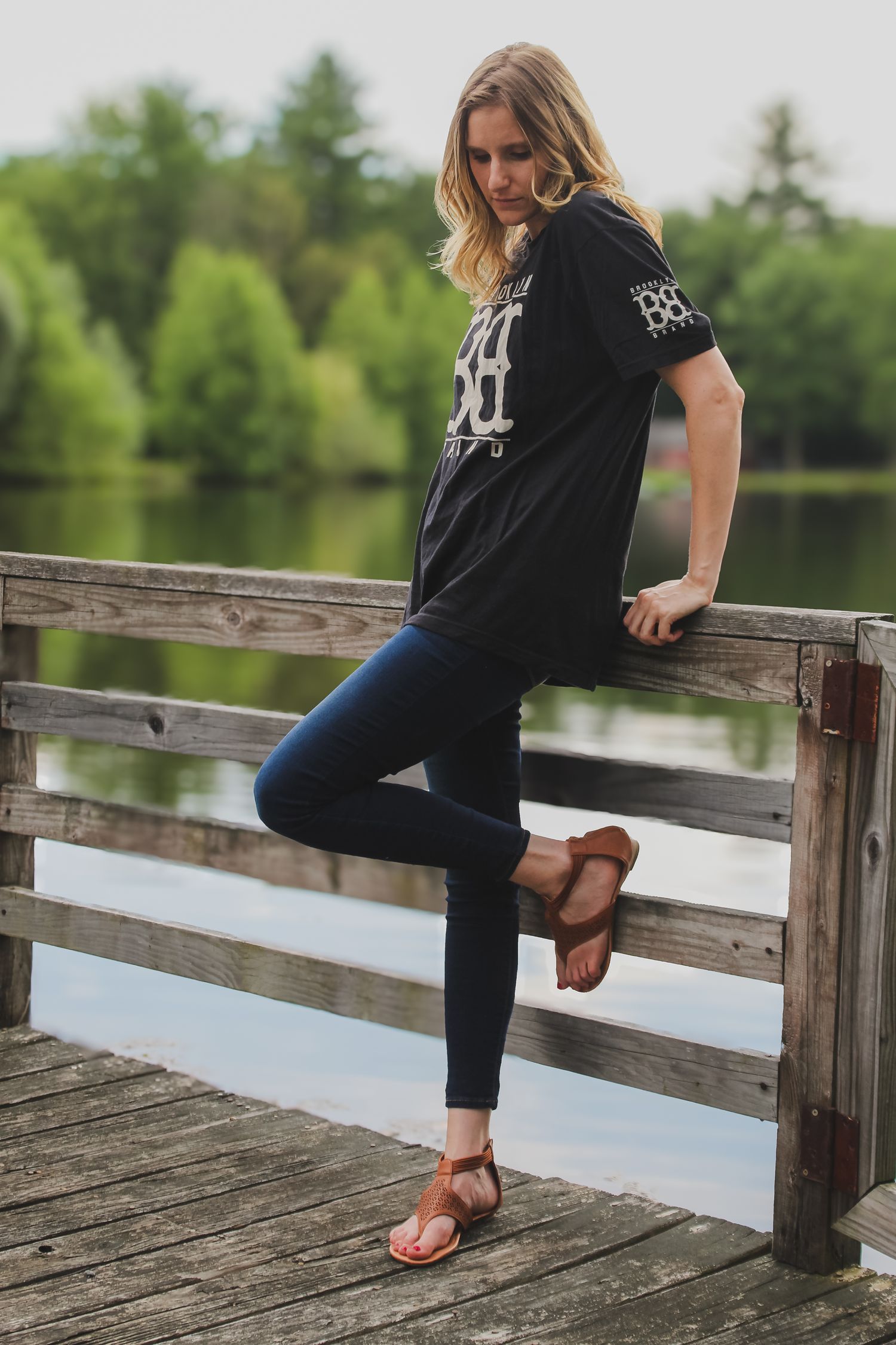A series of photos showing someone in a black t-shirt and jeans sitting on a wooden dock by a peaceful lake.