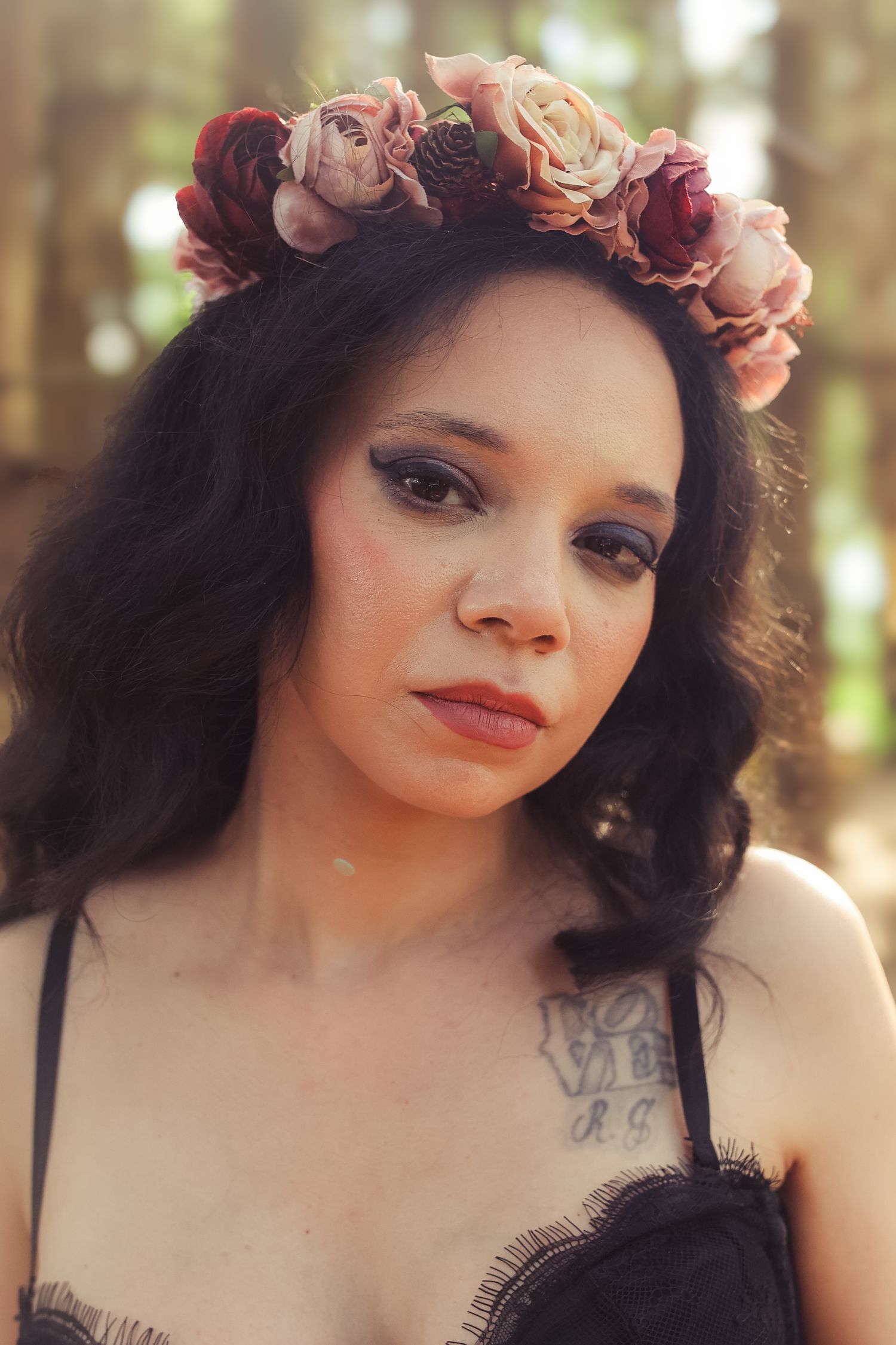 A portrait series featuring someone wearing a delicate floral crown of pink and peach roses against a soft forest backdrop.