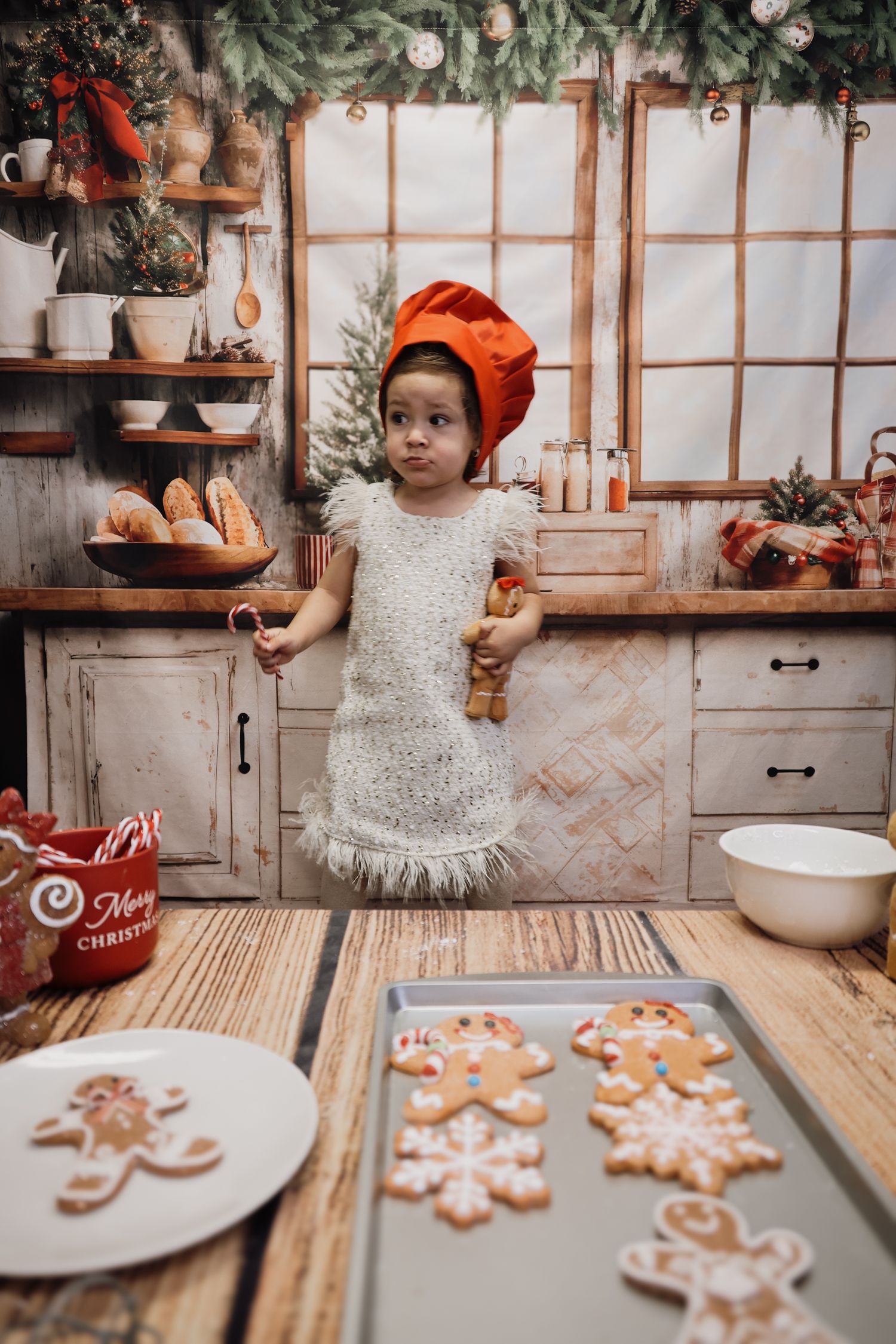 Cozy rustic kitchen scene with decorated gingerbread cookies laid out on baking sheets during holiday baking.