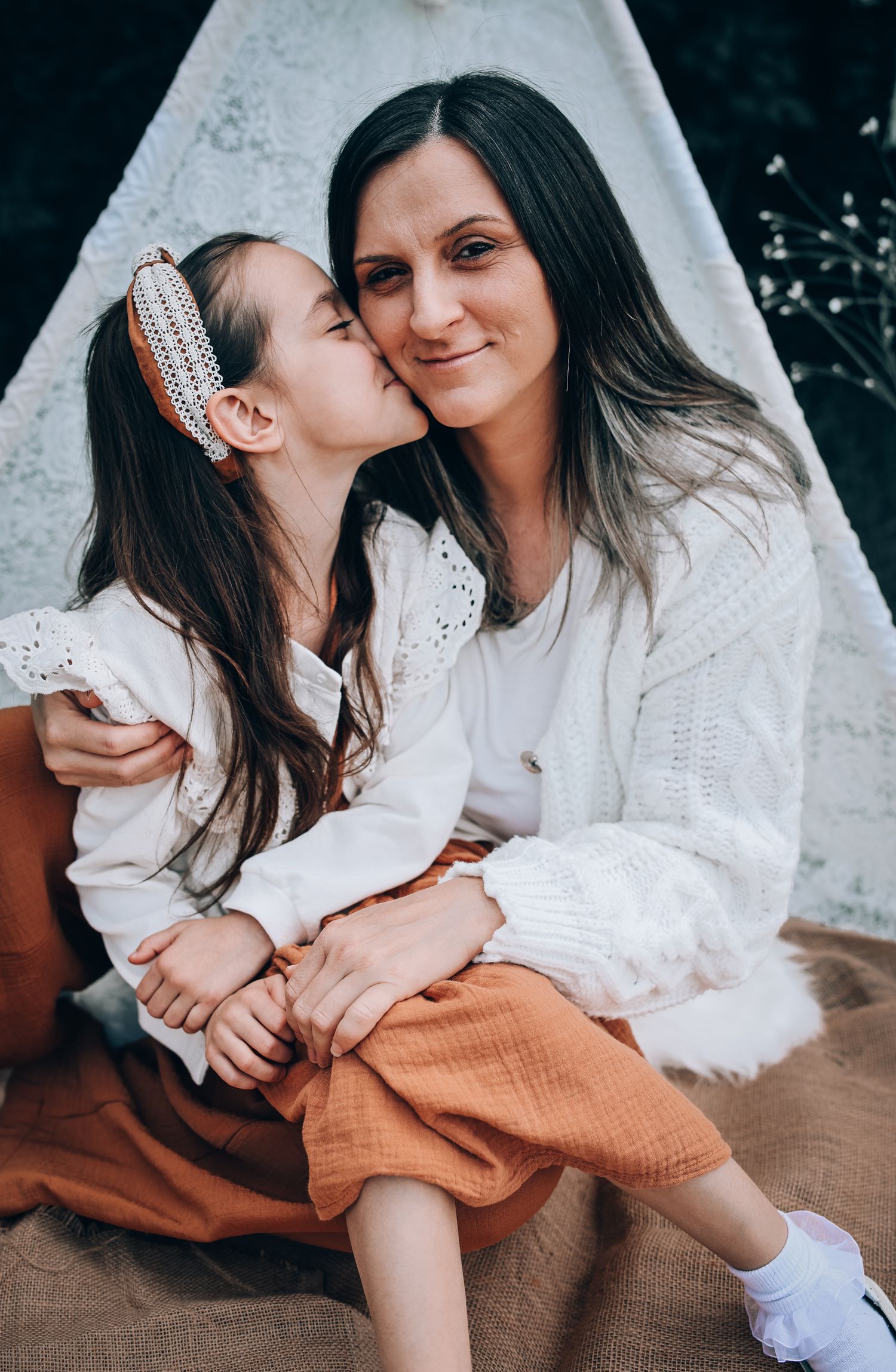 Two people in white tops and brown skirts share tender moments in a series of candid photographs.