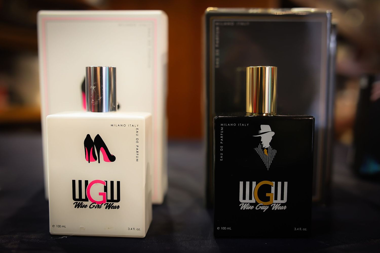 A row of white and black product boxes with WOW branding displayed on a dark wooden shelf.