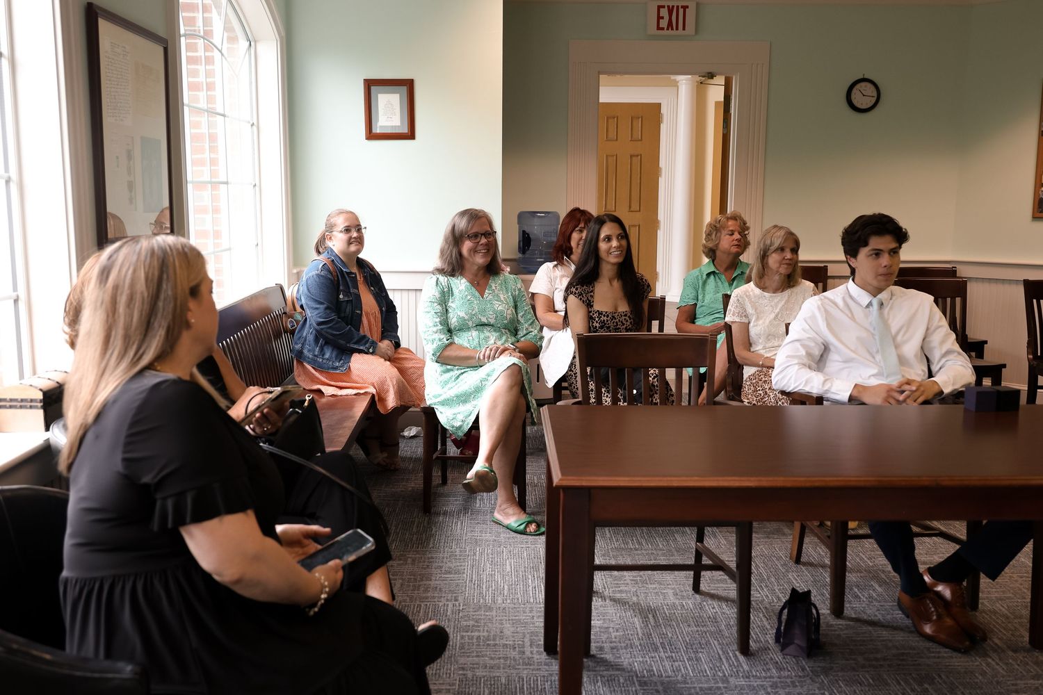 A group of people seated in a conference room during a meeting or presentation.