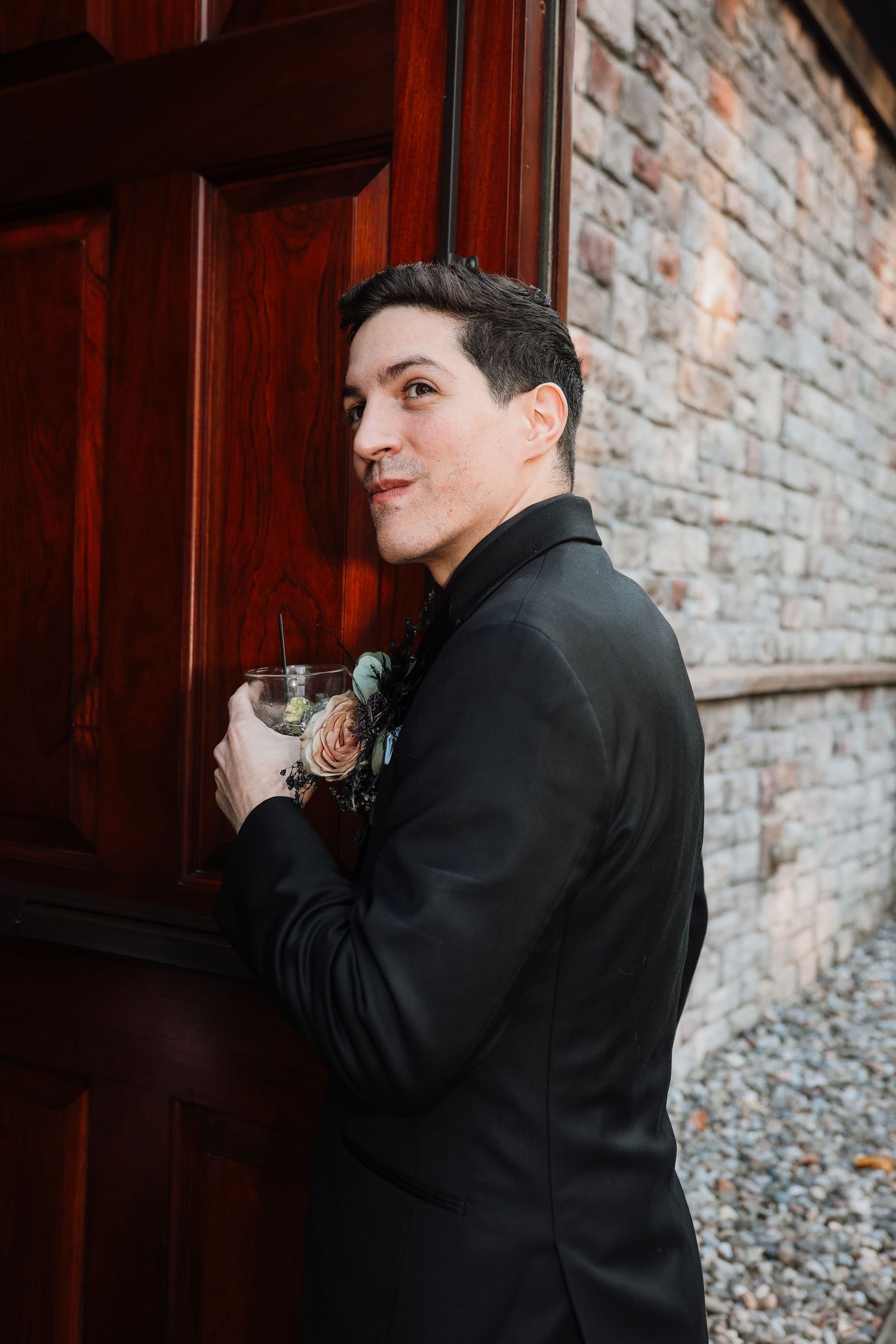 A sequence of photos showing someone in a black suit taking a sip from a glass against a brick wall background.