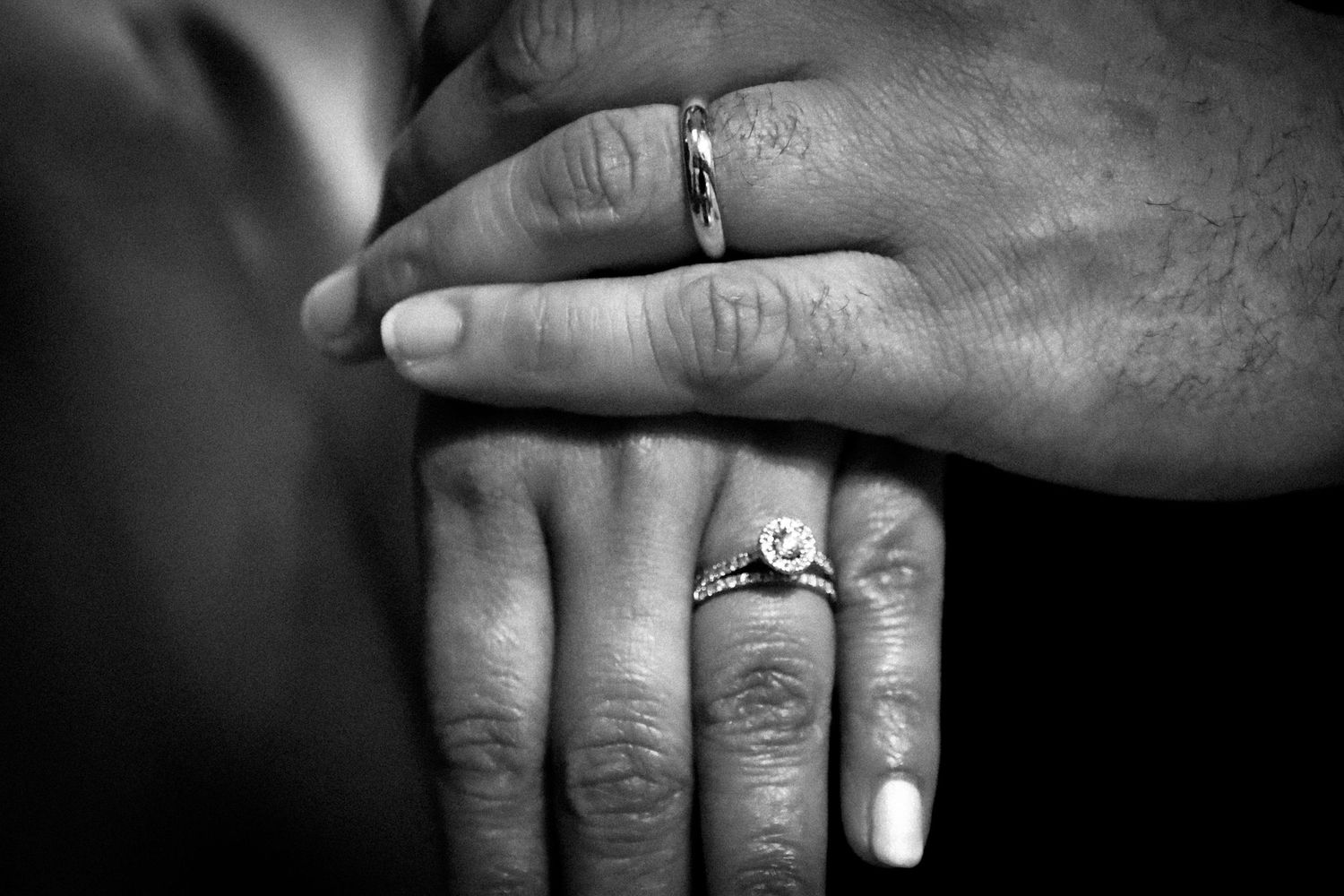 A series of black and white close-up photographs showing hands wearing engagement rings and wedding bands.