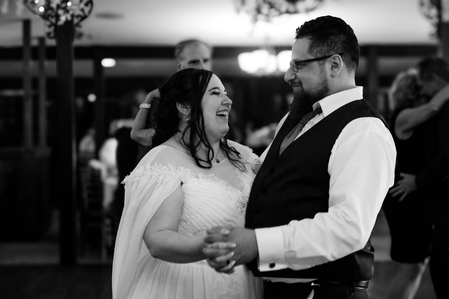 A joyful couple shares a dance together at a wedding reception.