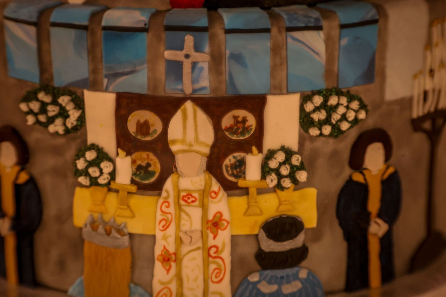 A series of colorful paintings depicting religious figures and scenes hang on display in an art gallery.