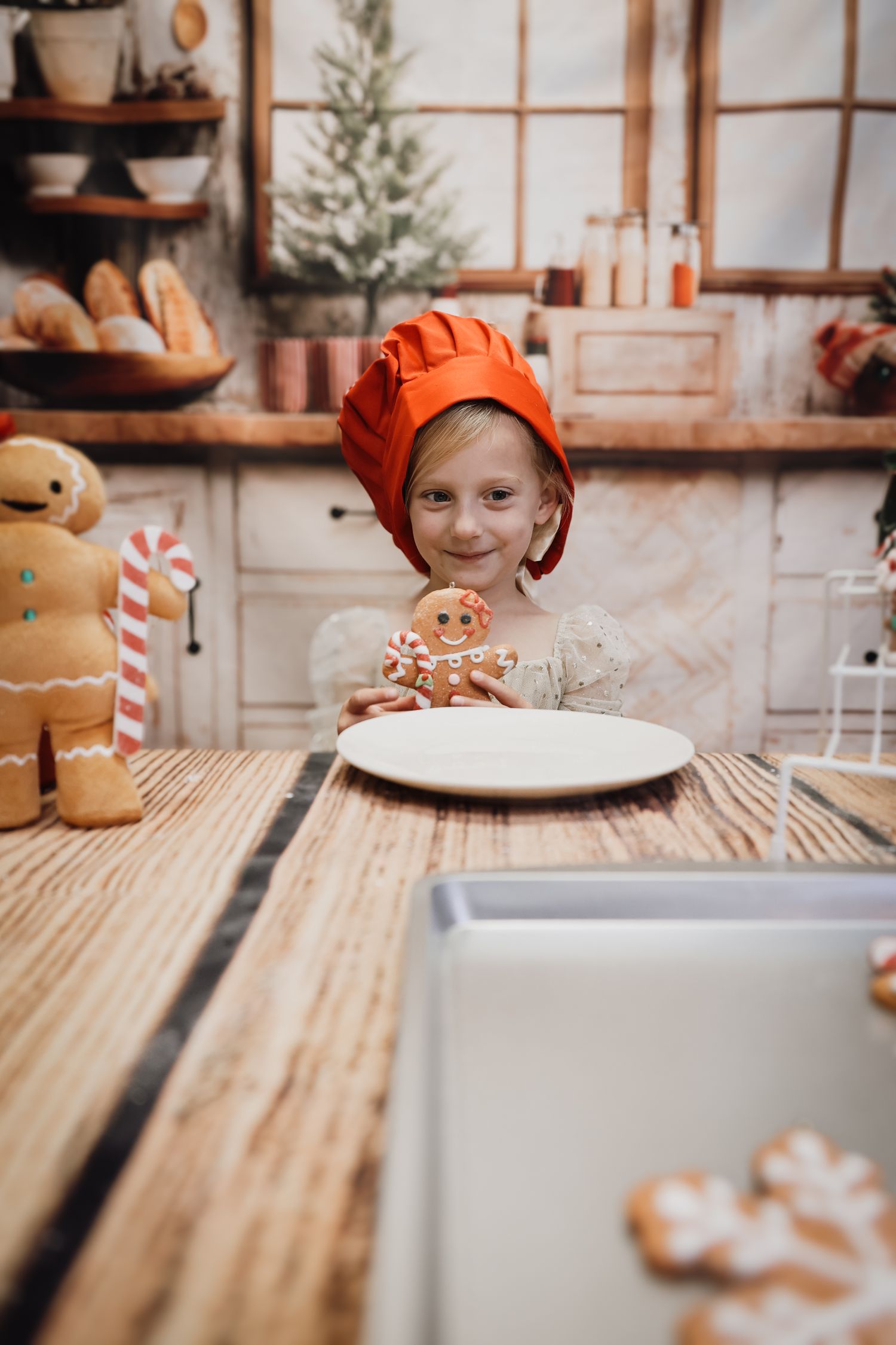 Gingerbread cookies and holiday treats arranged on a rustic wooden table with festive Christmas decor in the background.