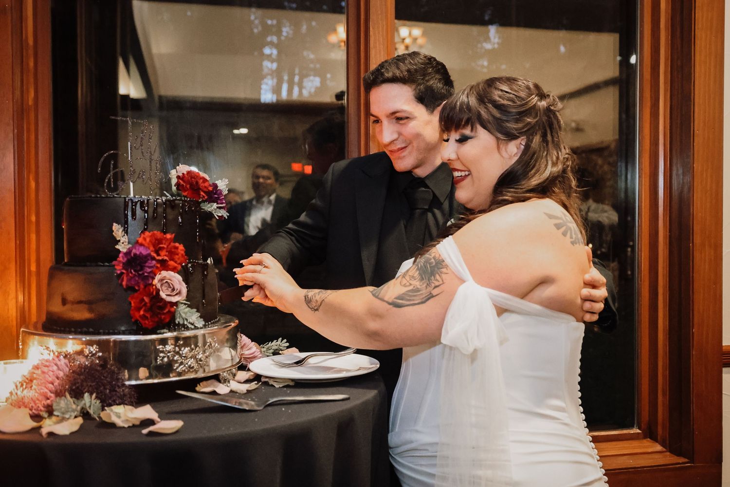 Wedding celebration scene in a warmly lit wooden interior setting.
