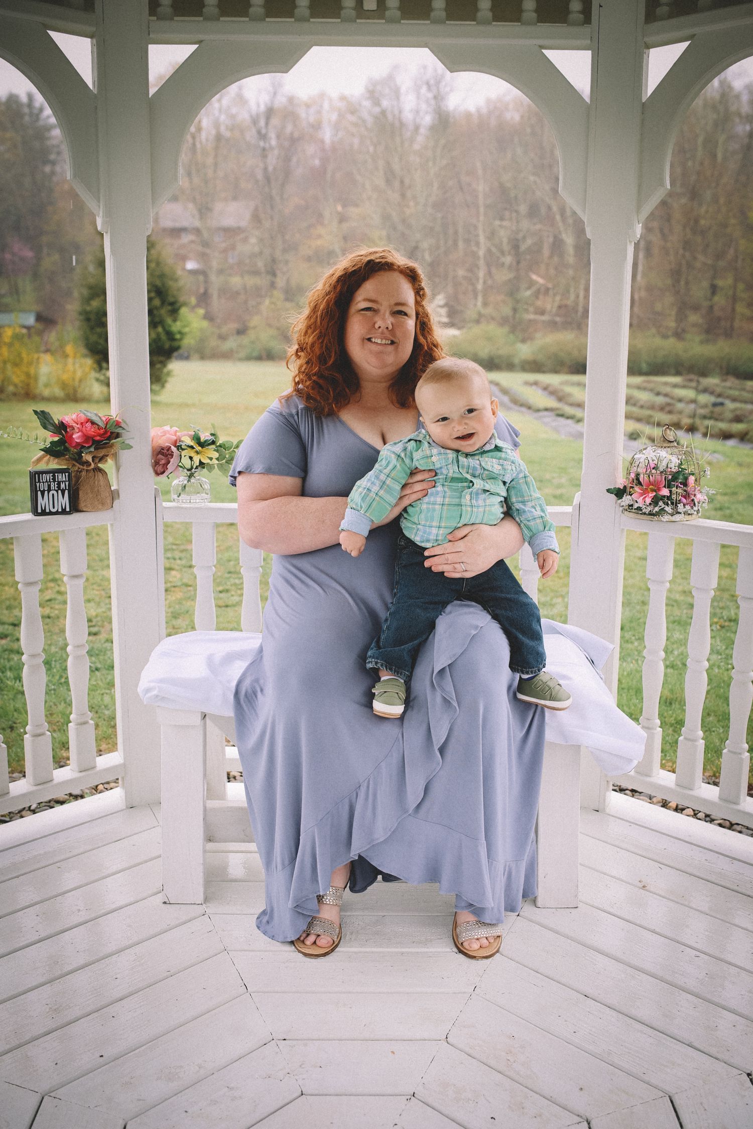 A heartwarming moment captured in a white gazebo with floral decorations and a beautiful natural backdrop.